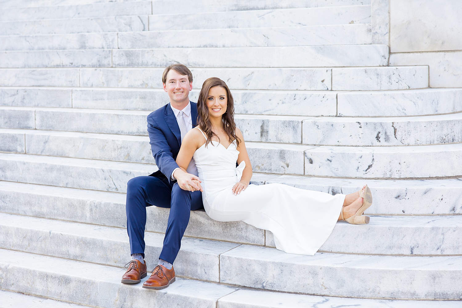 engaged couple sits on stairs of South Baptist church in Downtown Birmingham