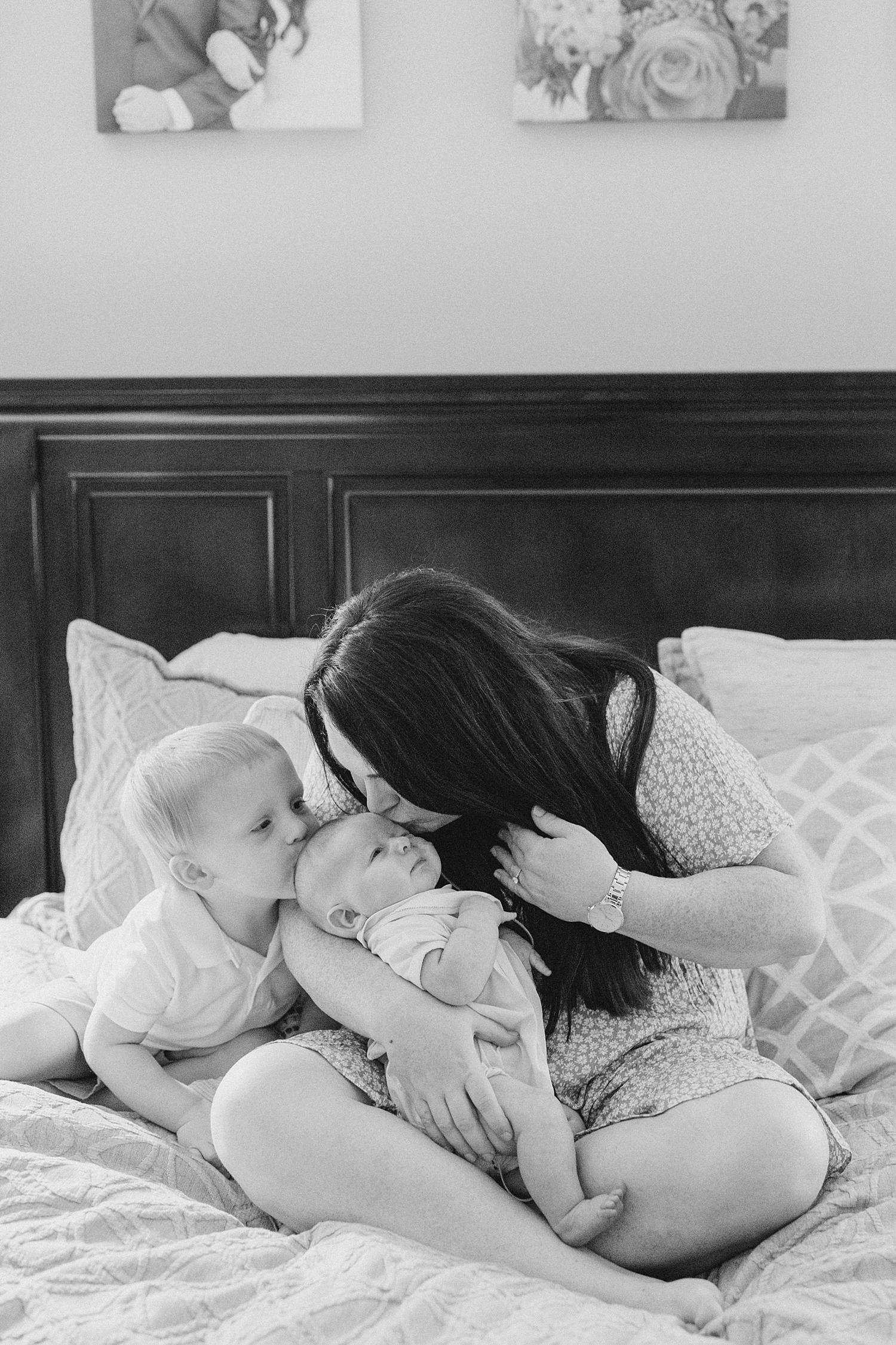 mom and big brother kiss newborn's head during Intimate at-home Newborn + Family Session 