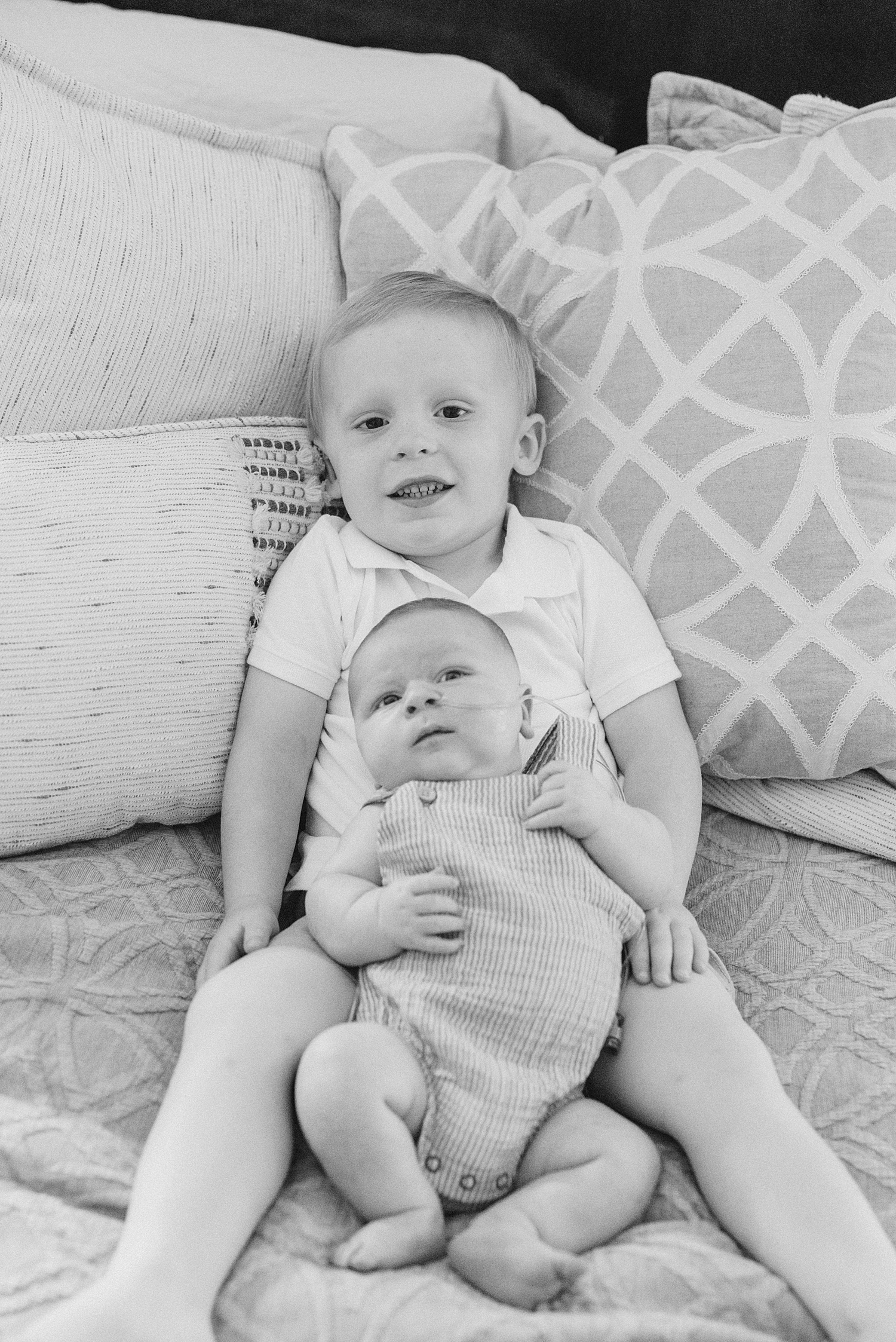 newborn brother sits with his big brother 