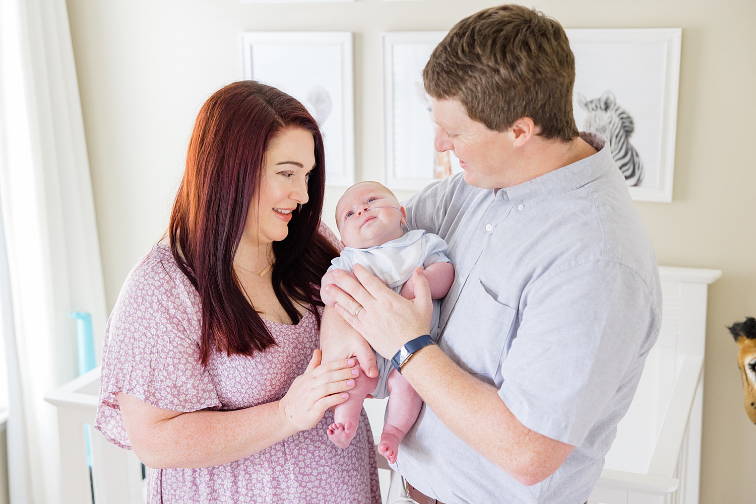 parents hold baby boy in nursery during Intimate at-home Newborn + Family Session 