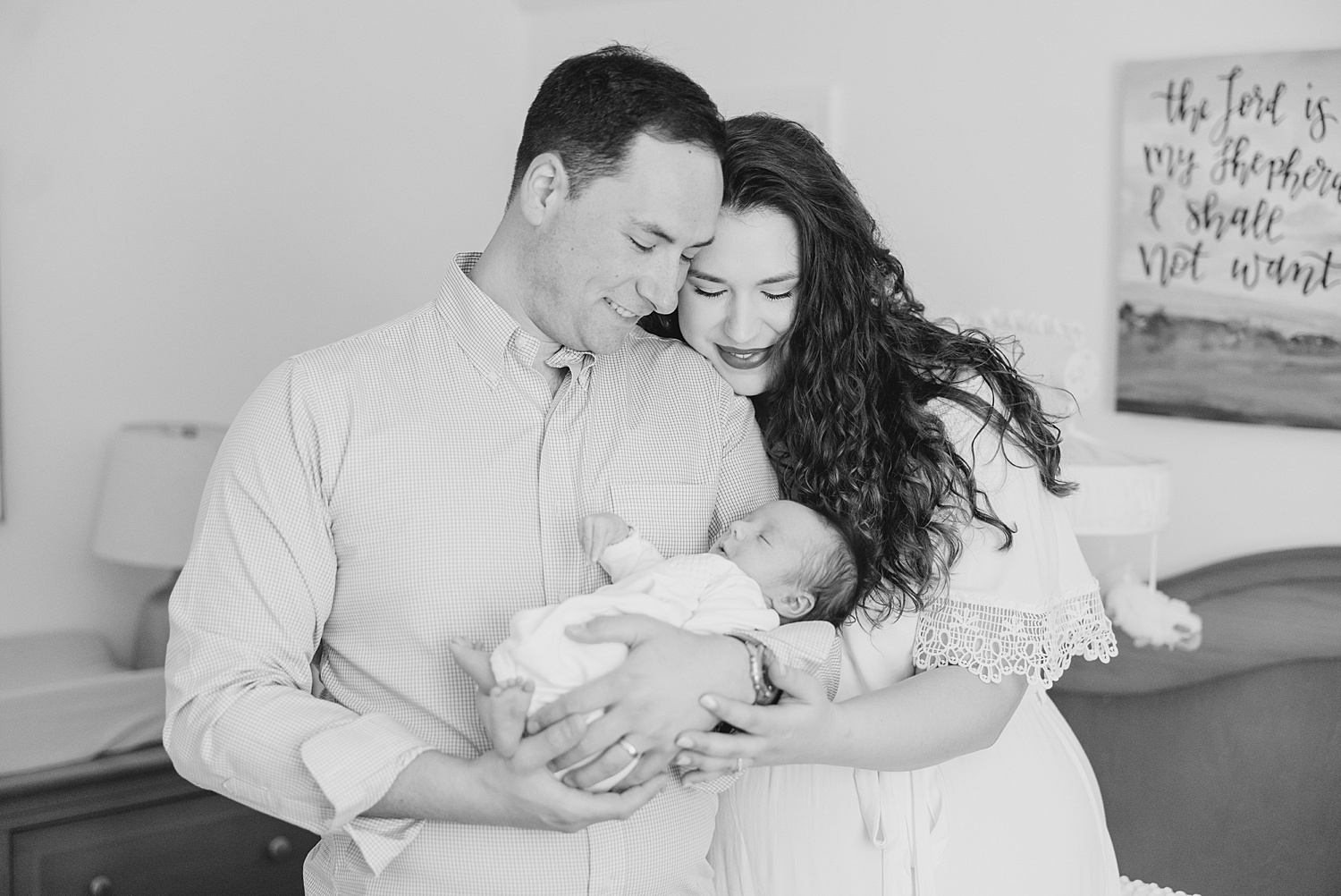 parents look down at baby as they hold