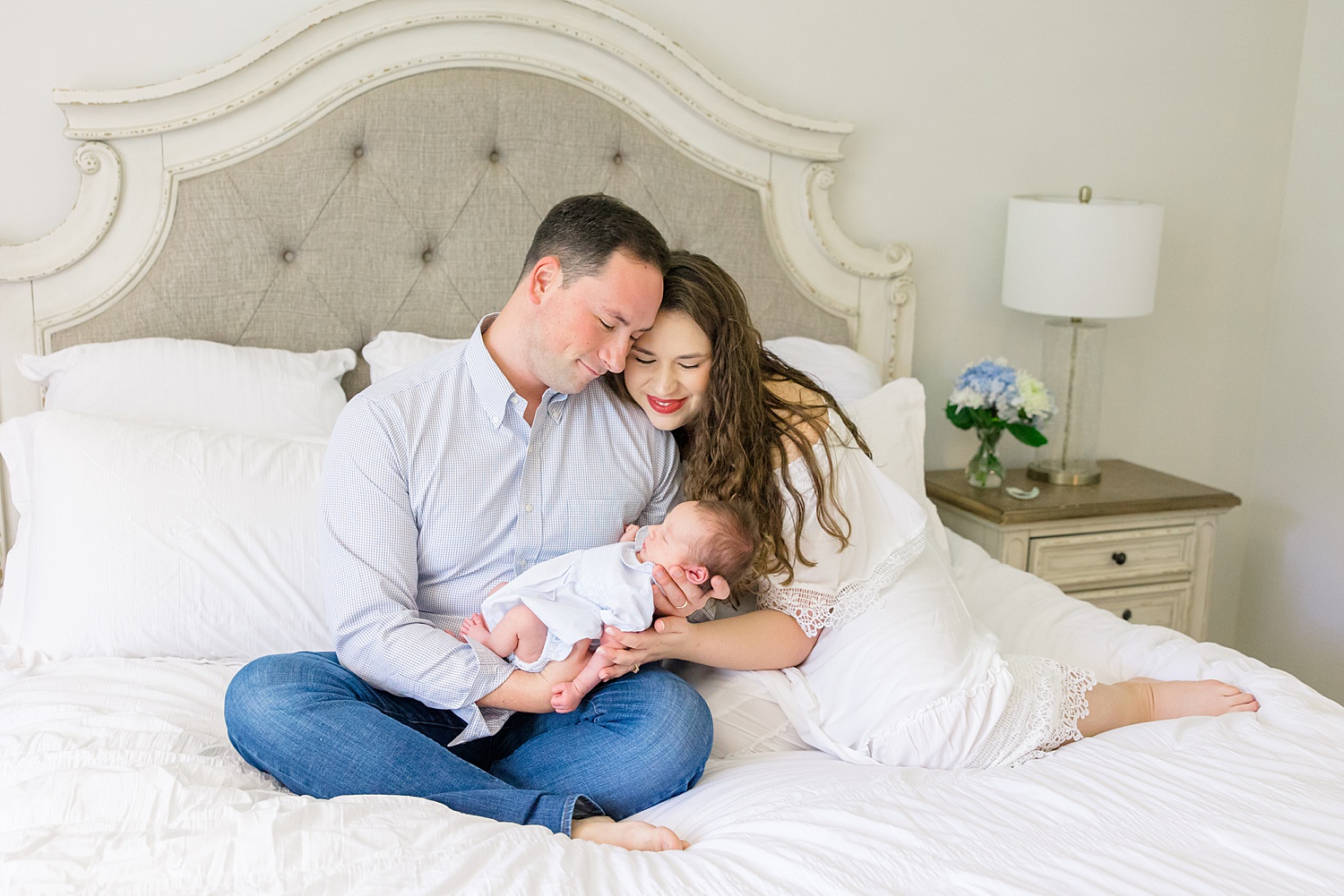 dad and mom hold baby on bed during At-home Newborn + Lifestyle session
