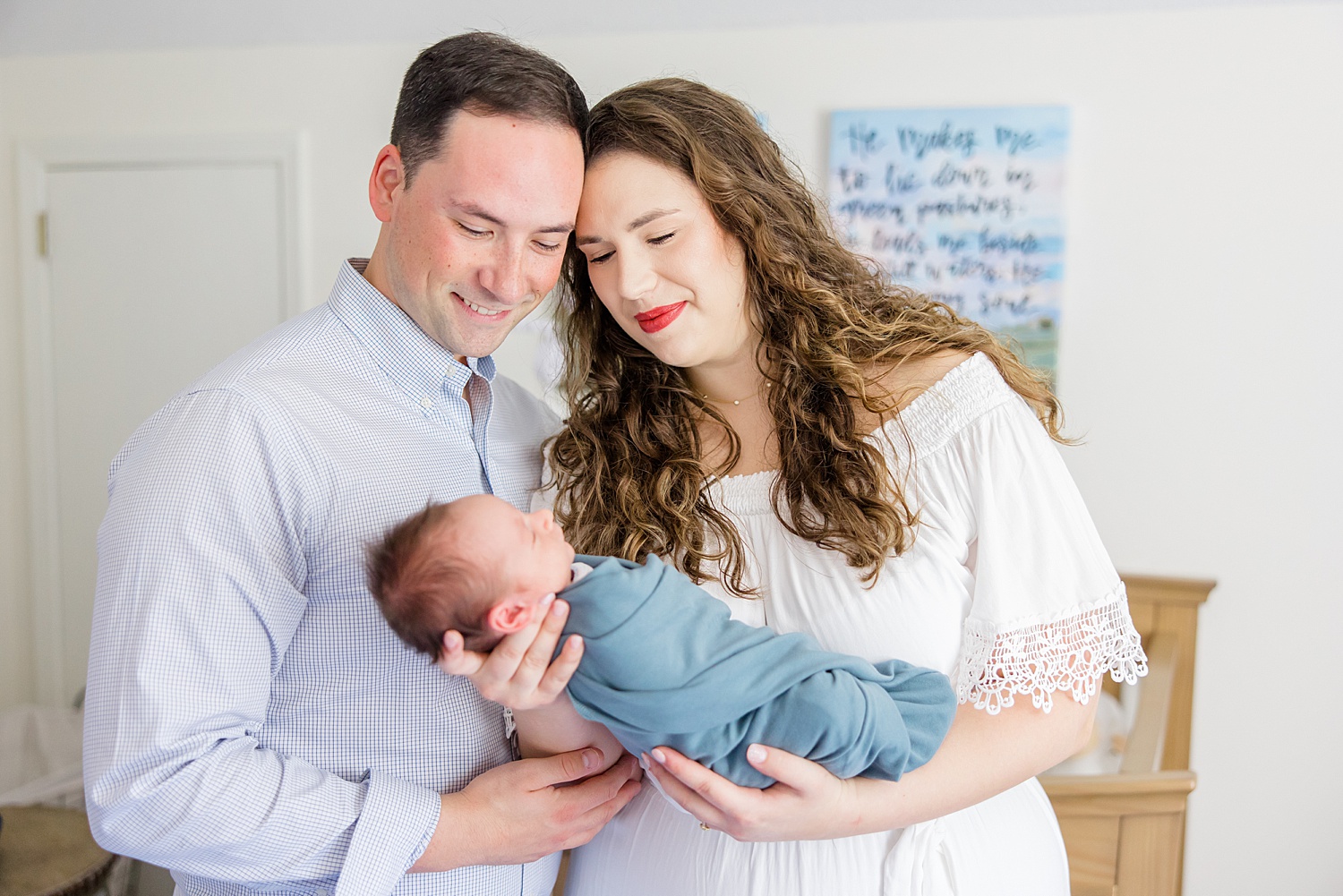 new parents look down at their son during At-home Newborn + Lifestyle session