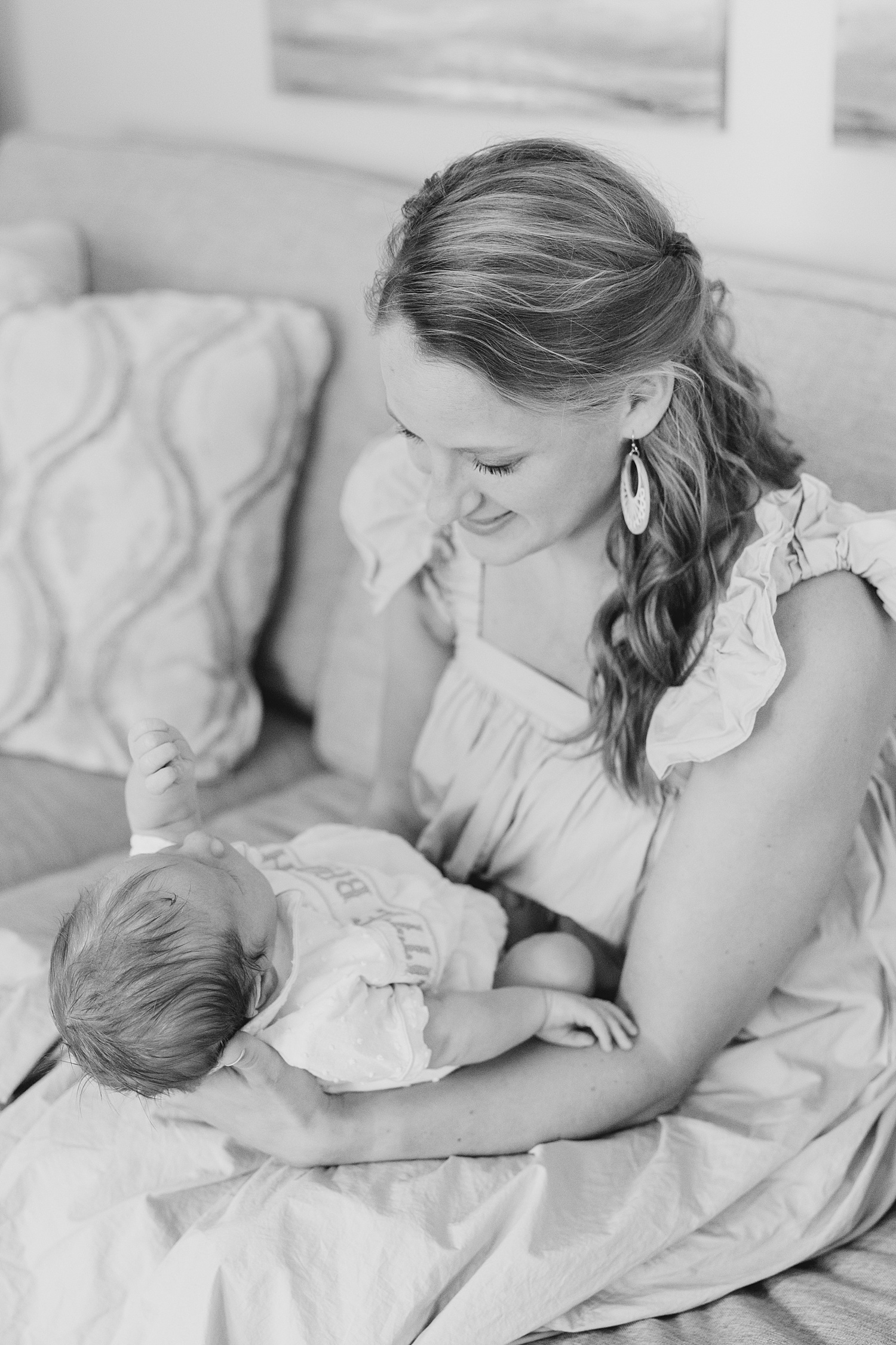 mom holds her newborn son out on her lap during Newborn and Family Milestone Portraits 