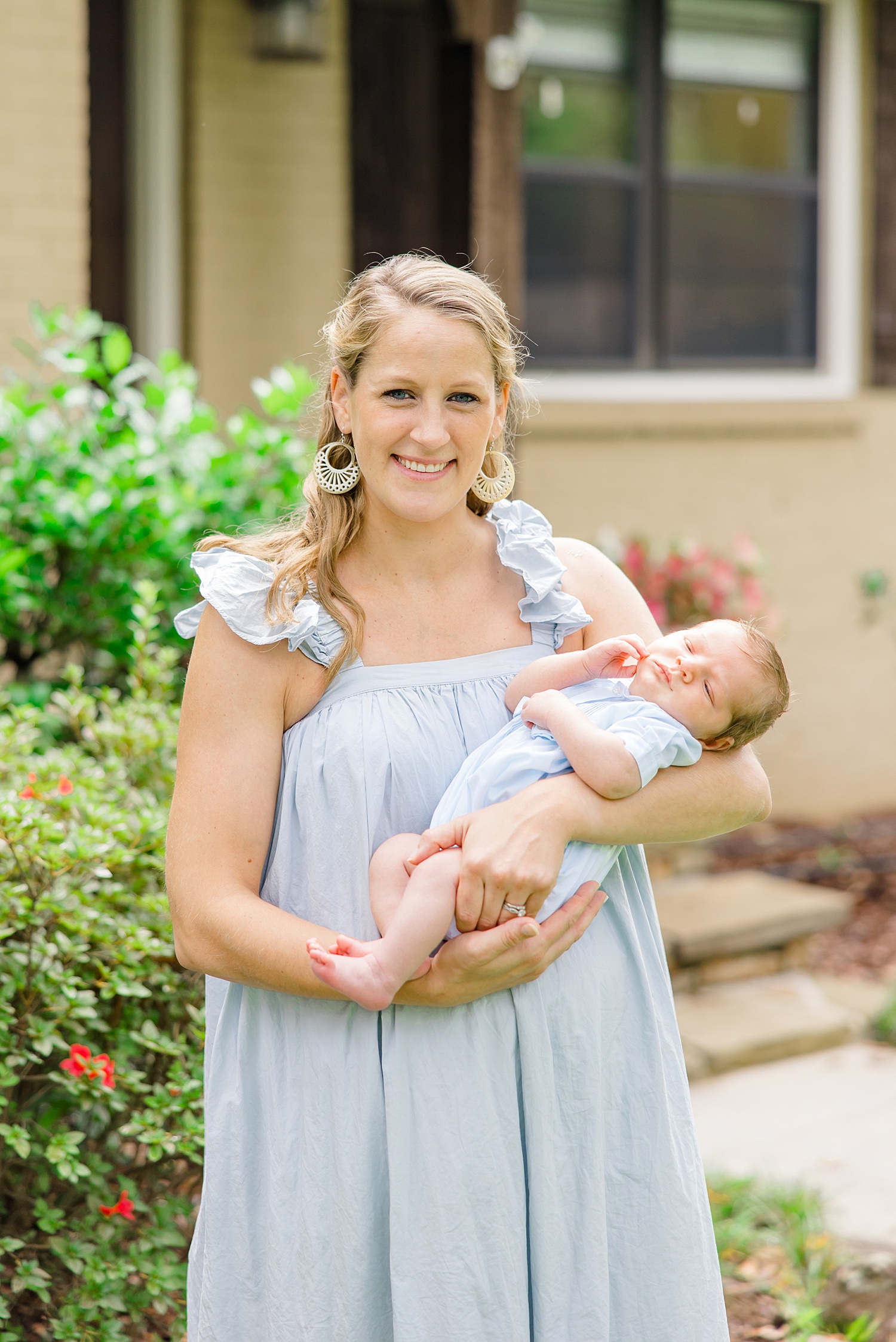 mom holds newborn son outside during Newborn and Family Milestone Portraits