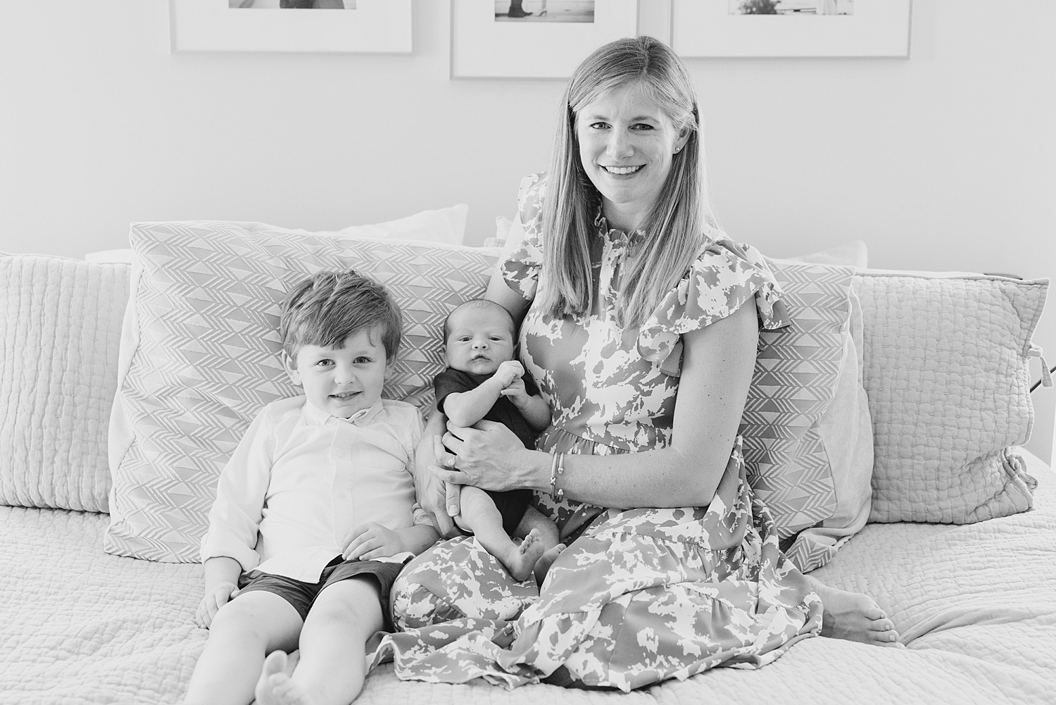 mom sits on couch with her two sons during Cozy In-Home Newborn Session