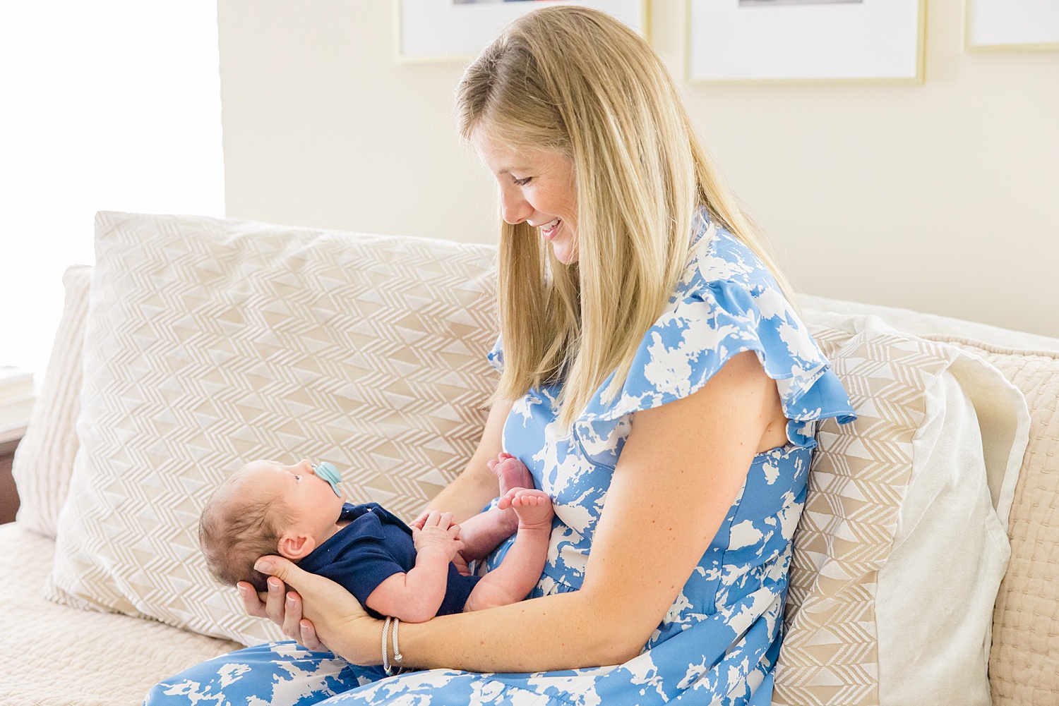 mom holds newborn in lap during in home session