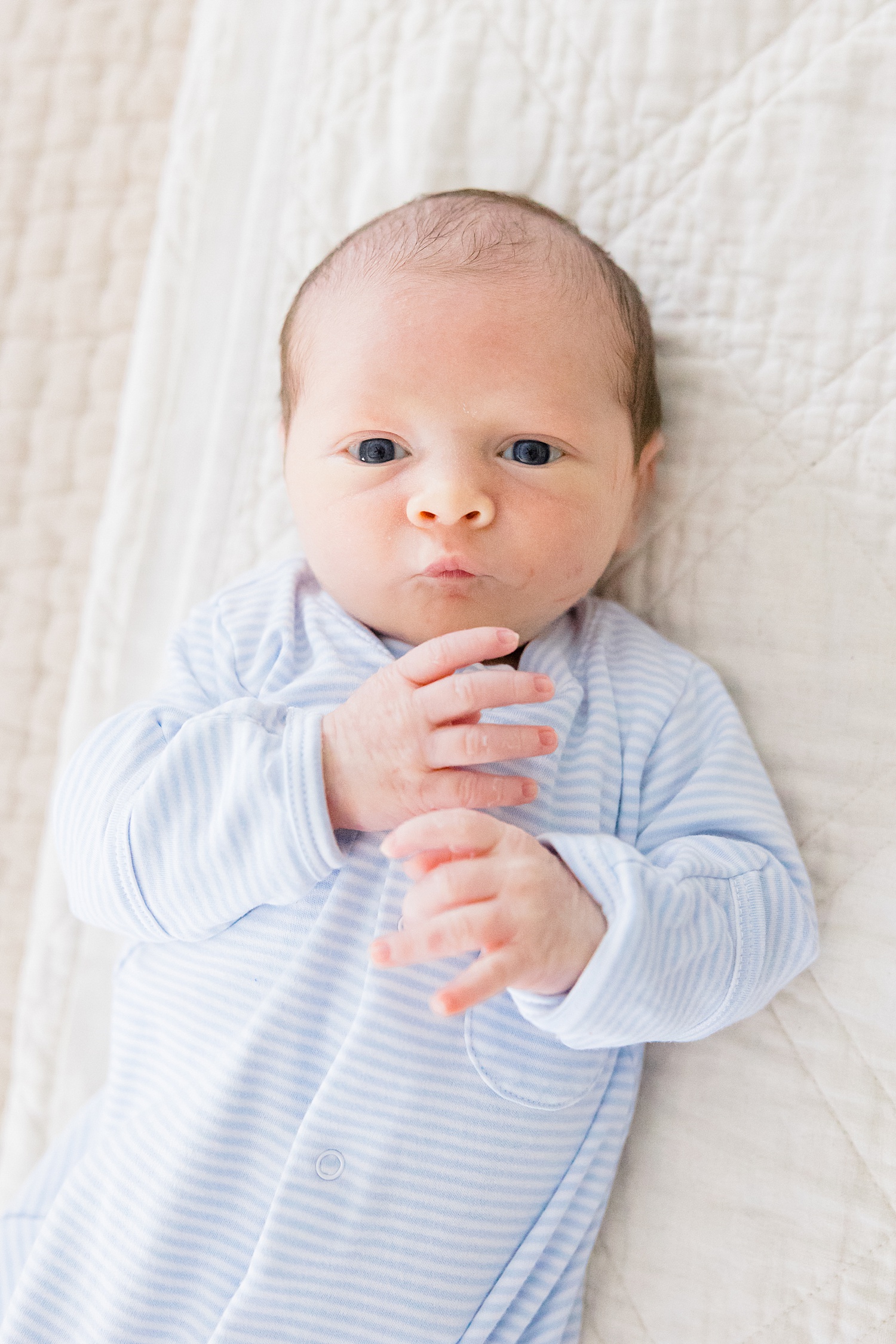 adorable newborn makes facial expressions during Cozy In-Home Newborn Session