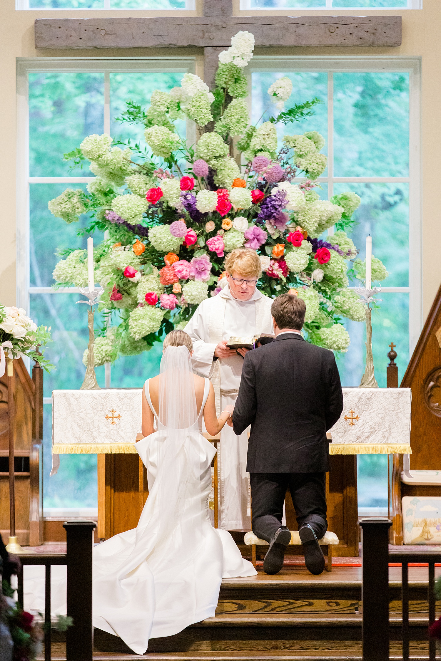 couple kneel at altar of wedding ceremony
