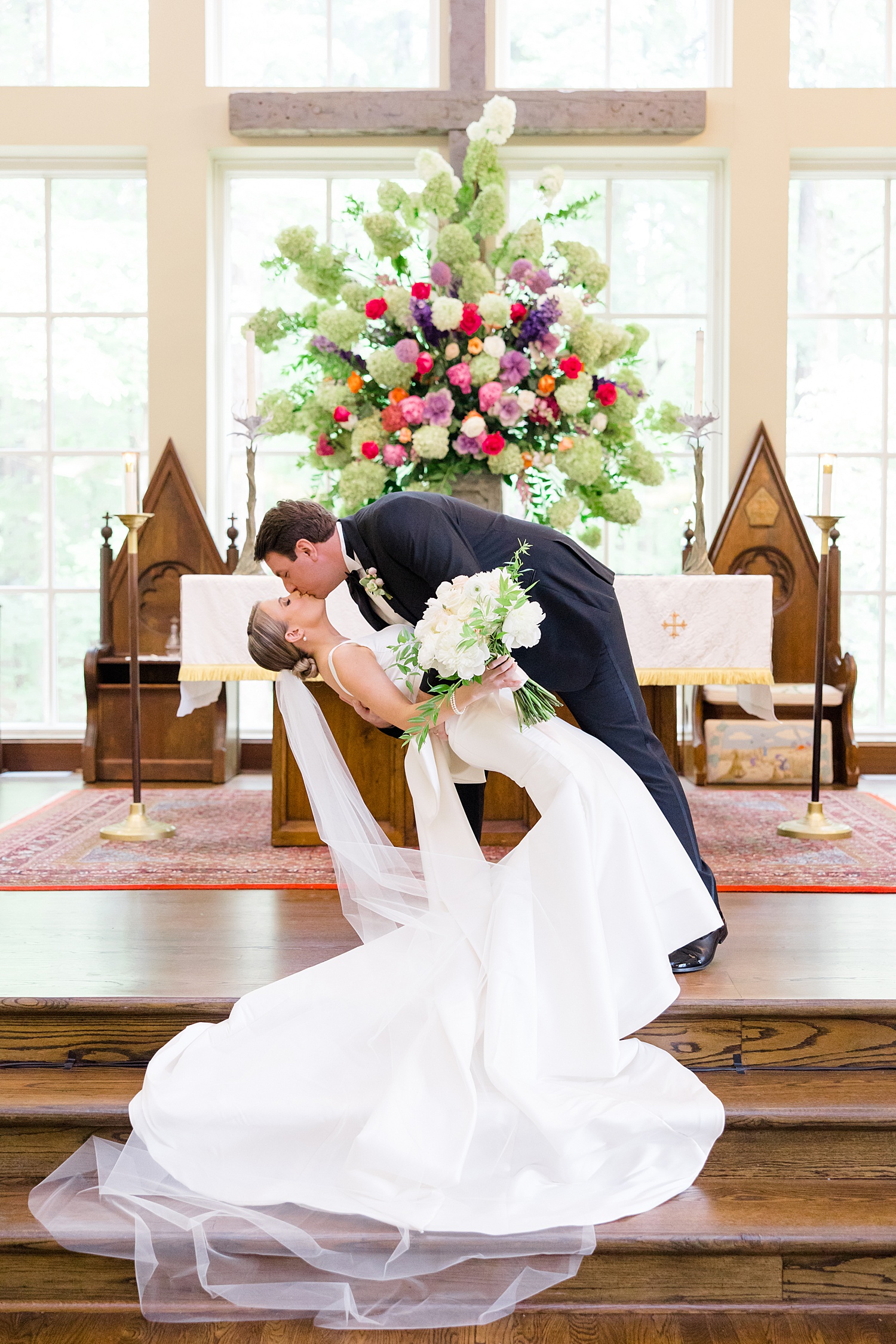 husband dips his wife on the altar at church