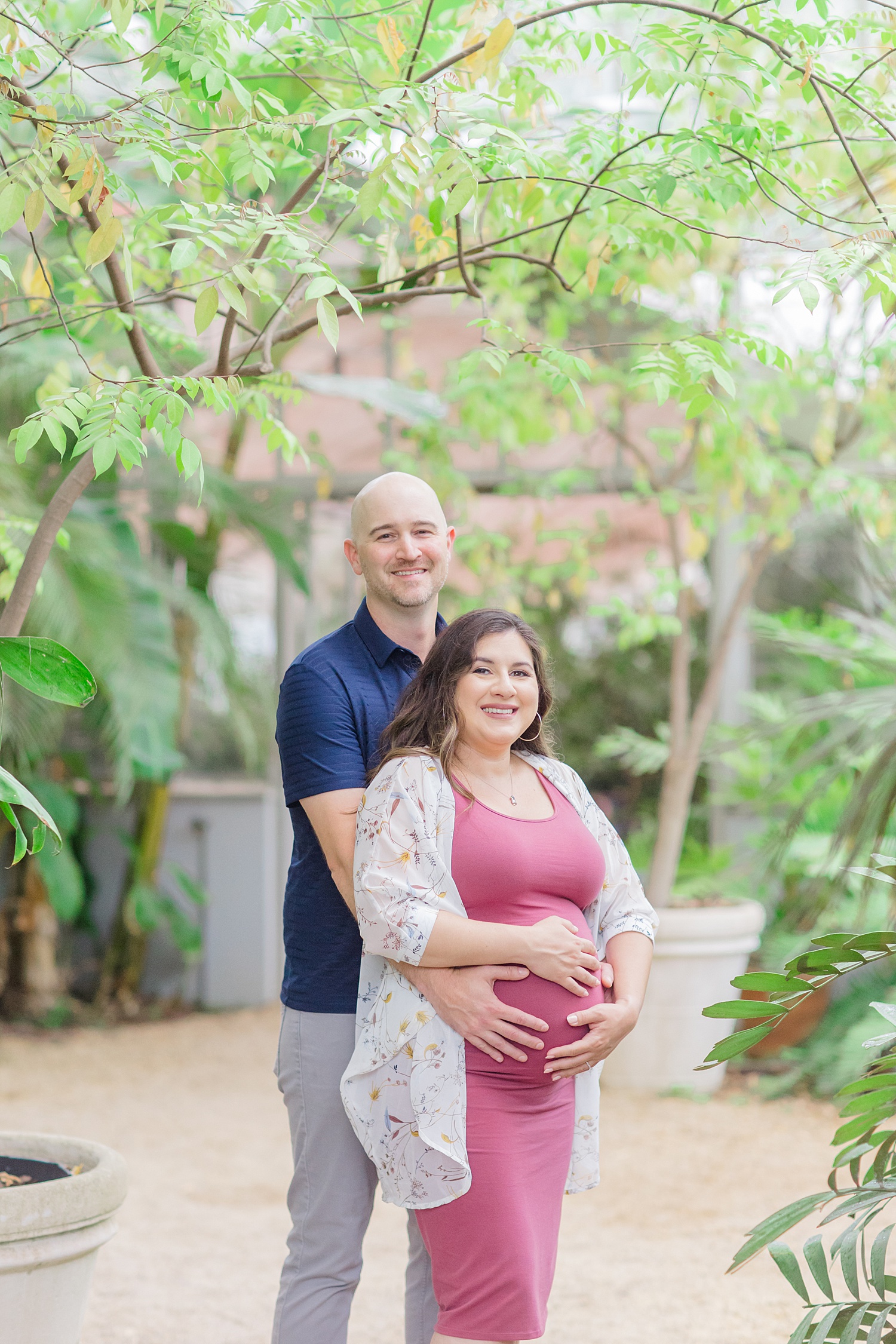 couple place on hands on baby bump during maternity portraits 