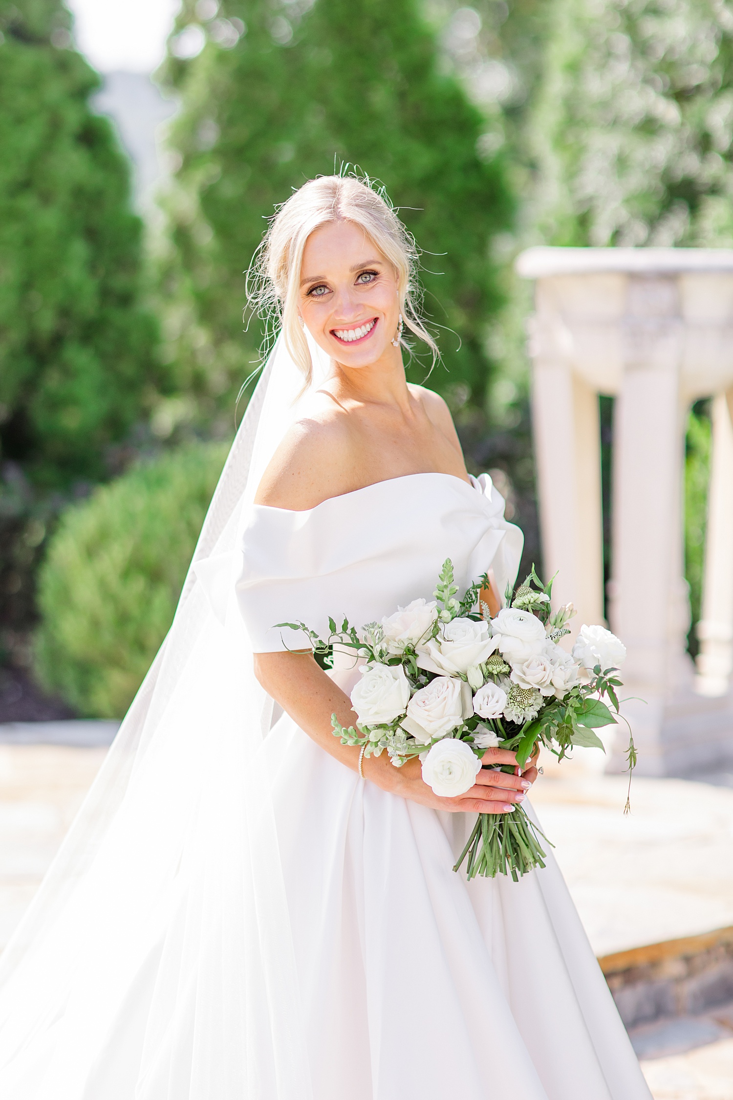 stunning bride in off shoulder wedding dress and classic white bouquet 