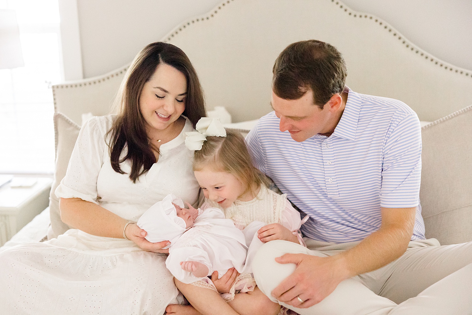 family of four snuggles on bed during In-Home Newborn Lifestyle Portraits in Trussville, AL 