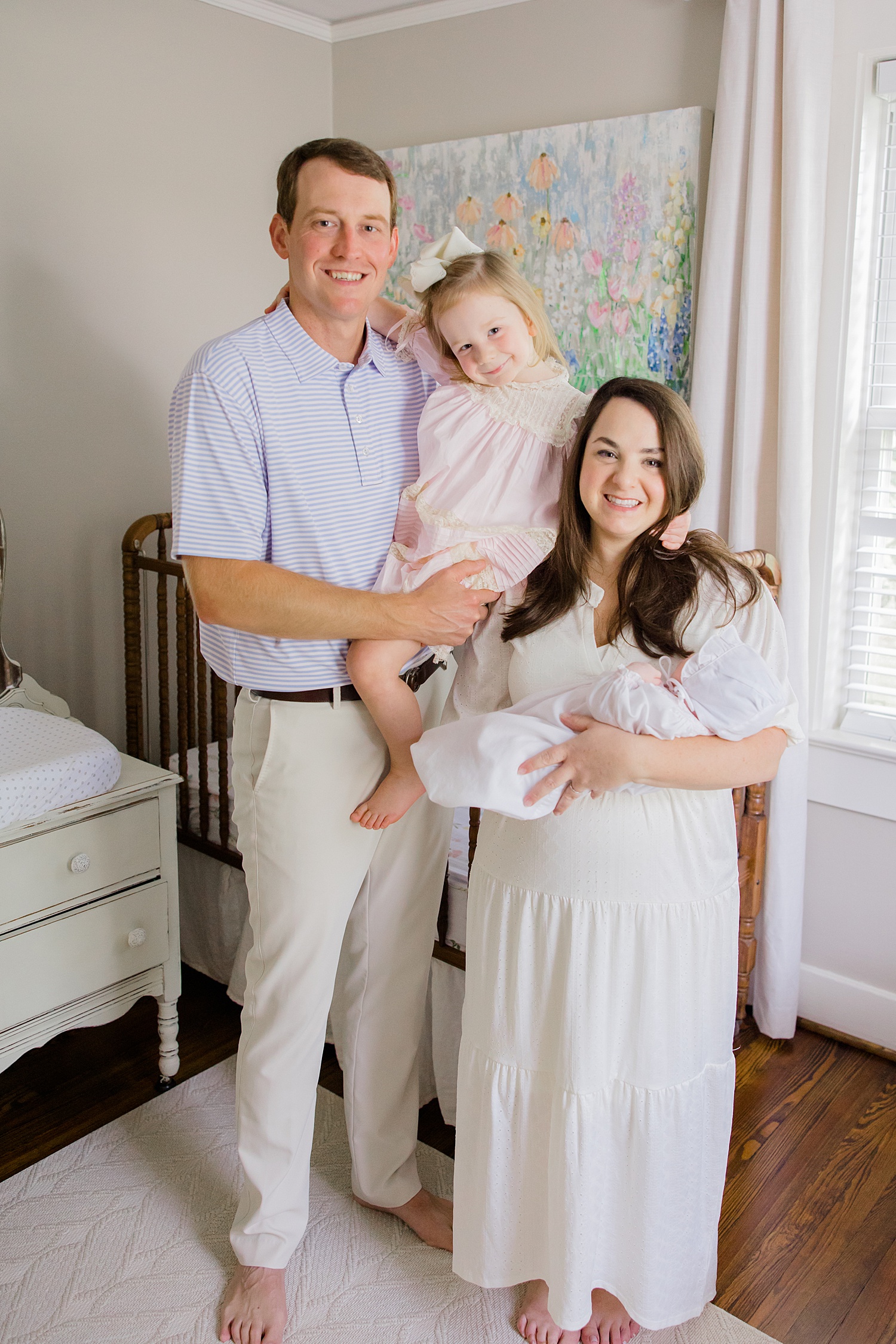 family of four stand in newborn's nursery during In-Home Newborn Lifestyle Portraits in Trussville, AL 