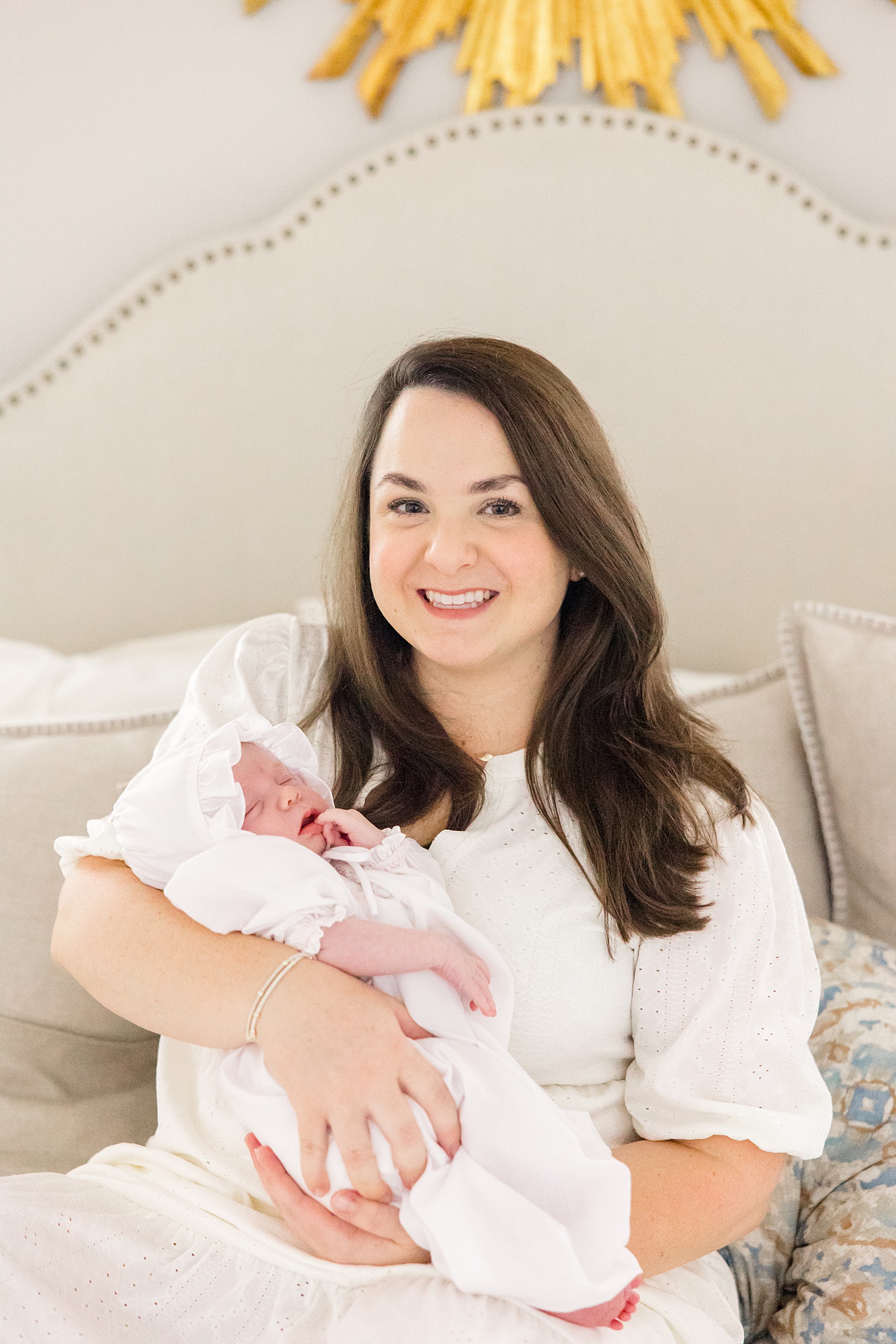mom holds newborn baby during in-home lifestyle portraits