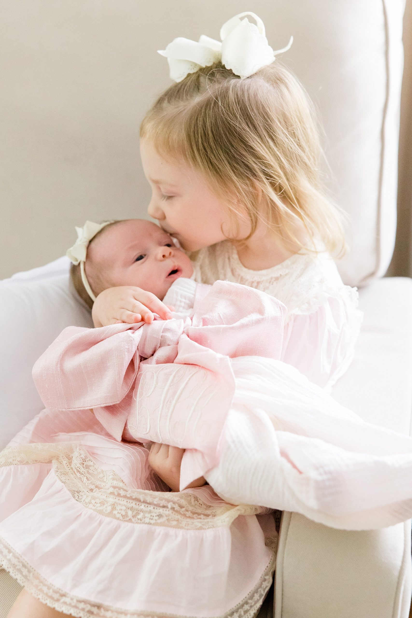 big sister kisses her little sister on the head