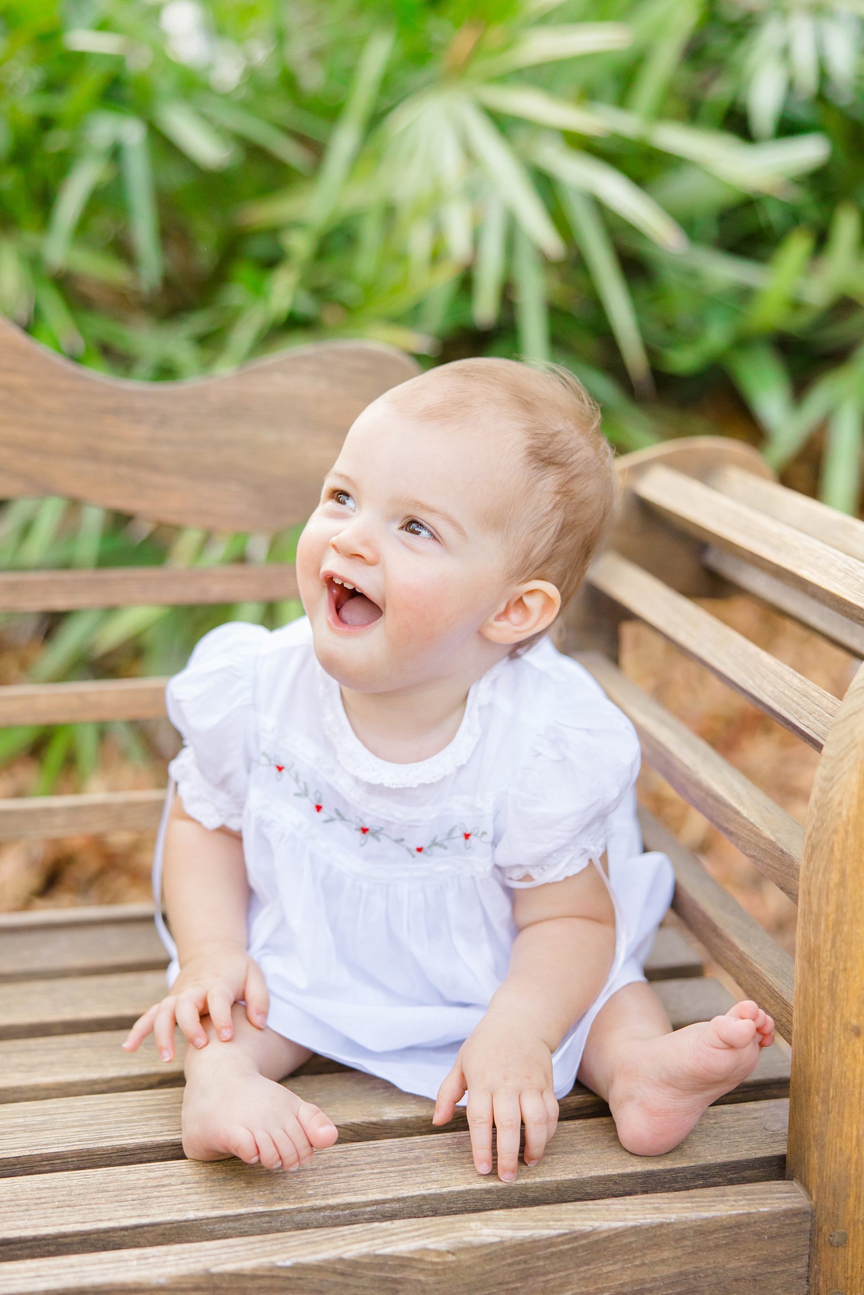 little girl sits on bench at Birmingham Botanical Gardens