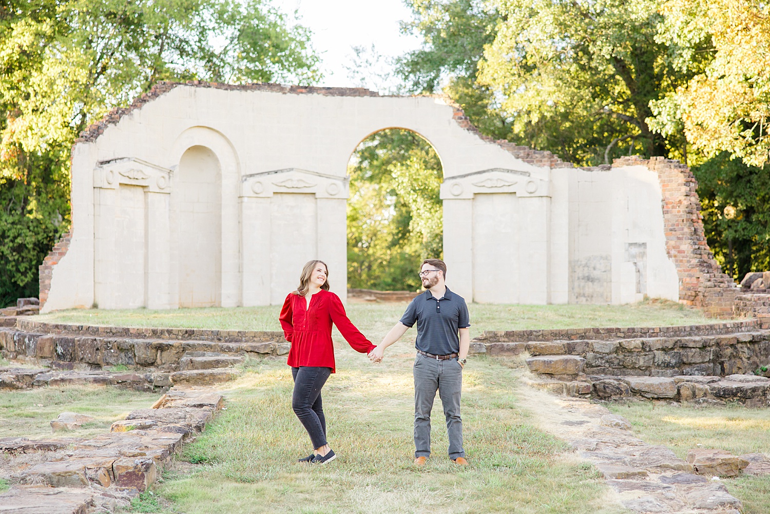 couple walk together holding hands during Riverwalk and Capitol Park Engagement in Tuscaloosa, Alabama