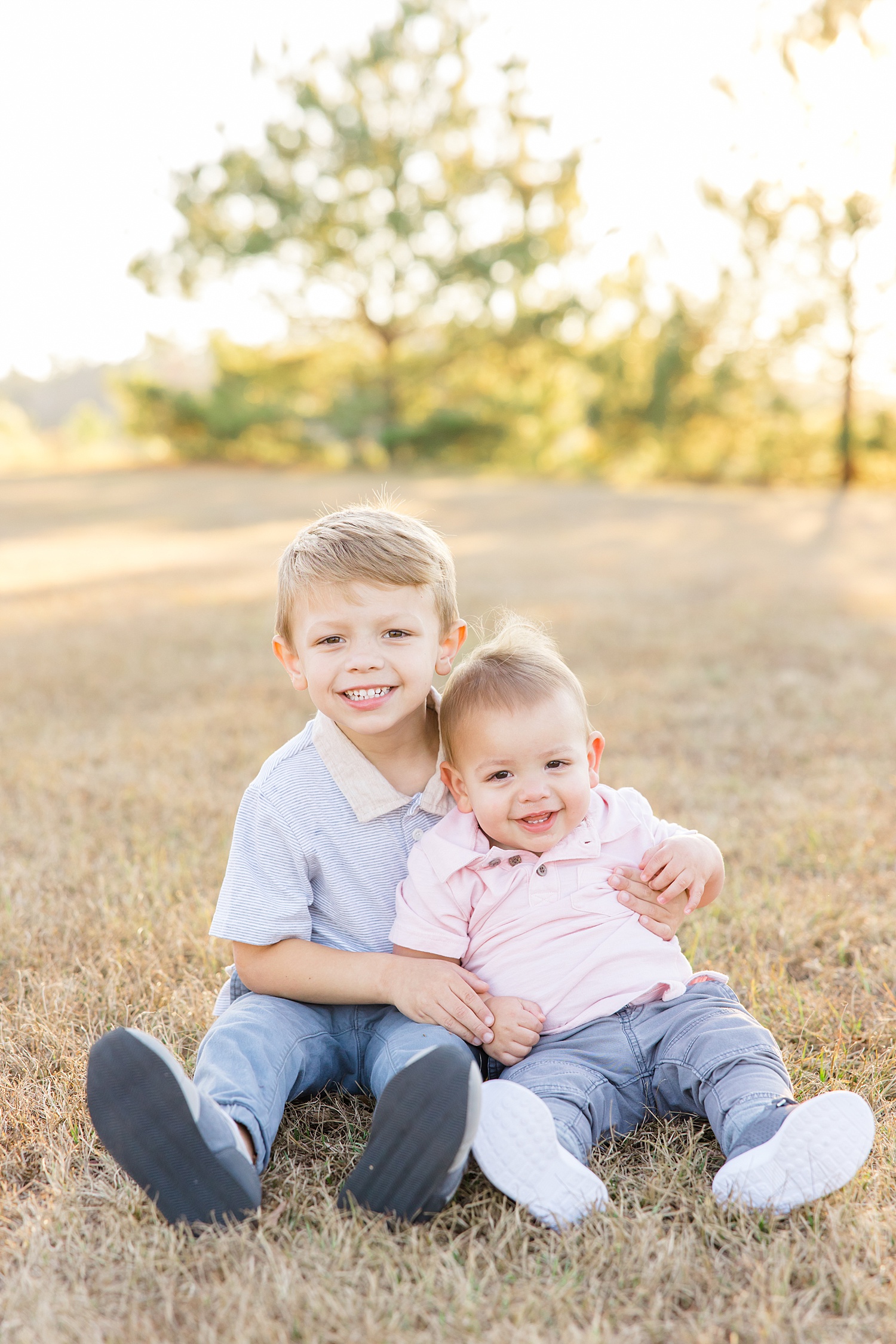 brothers sit together on the ground during Birmingham Fall Family Session