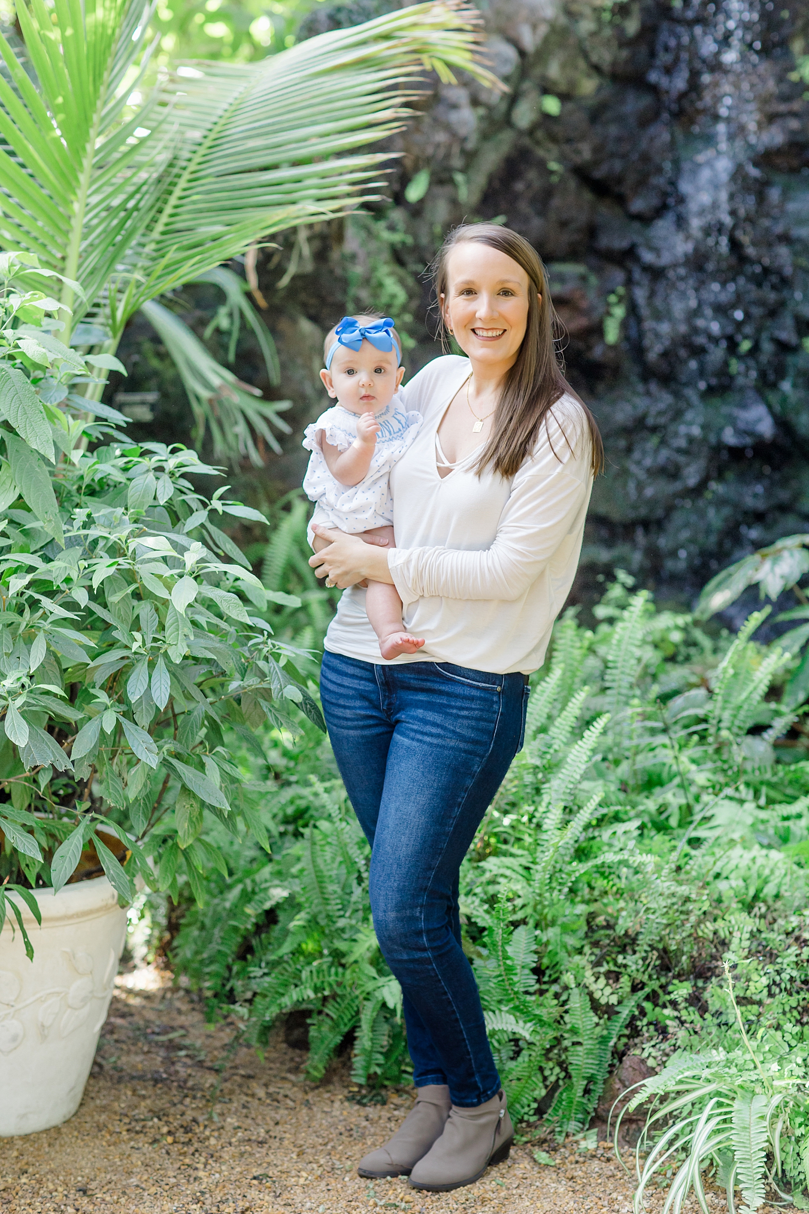 mom holds baby girl in botanical gardens