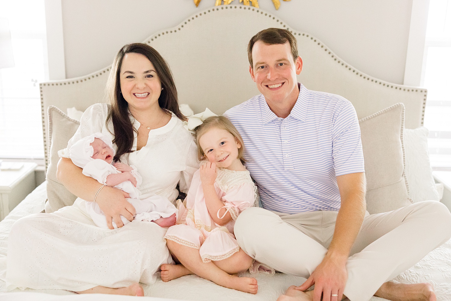 family of four sits on bed during Birmingham Family Sessions of 2022