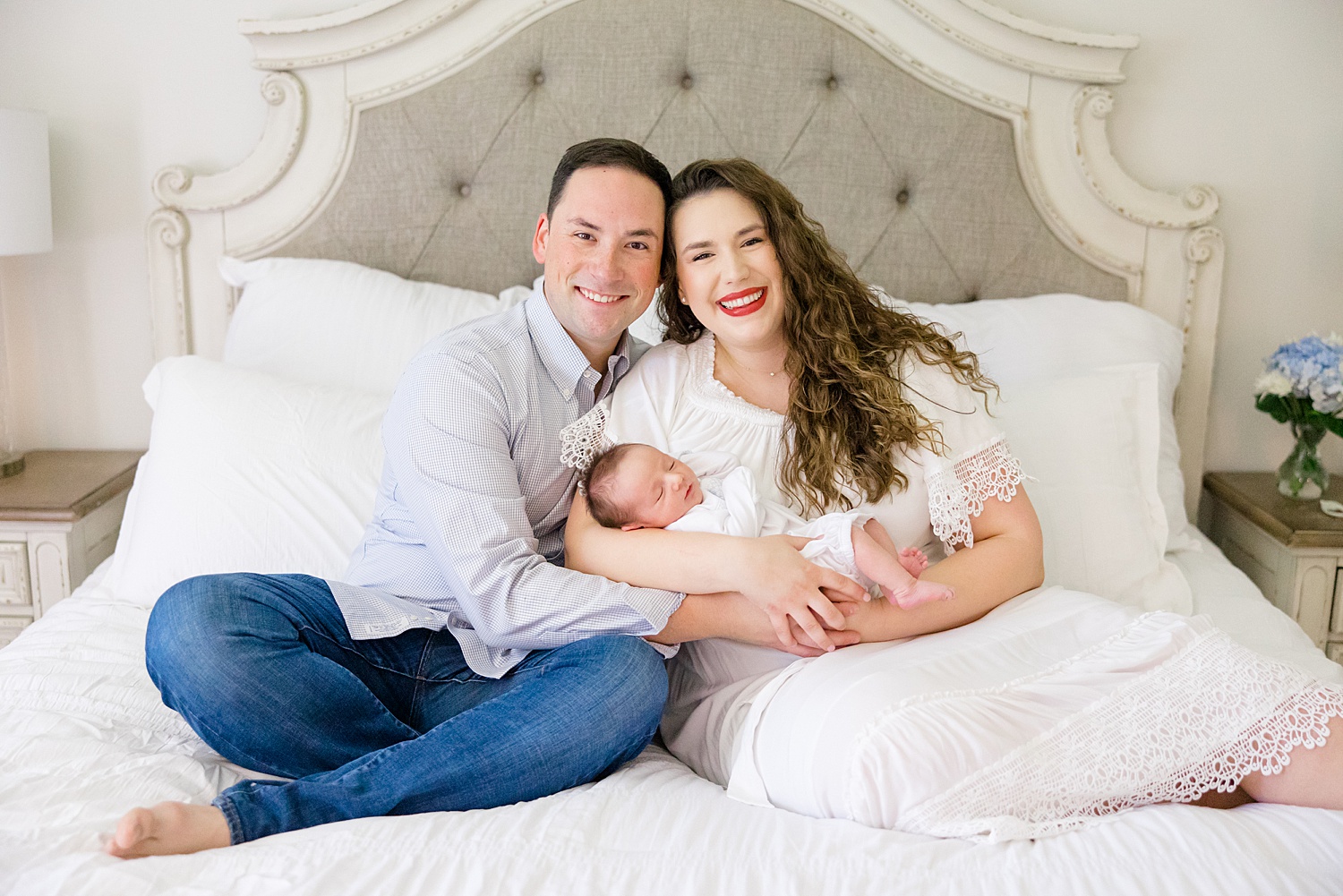 family of three sit on bed during in-home newborn session in Birmingham AL