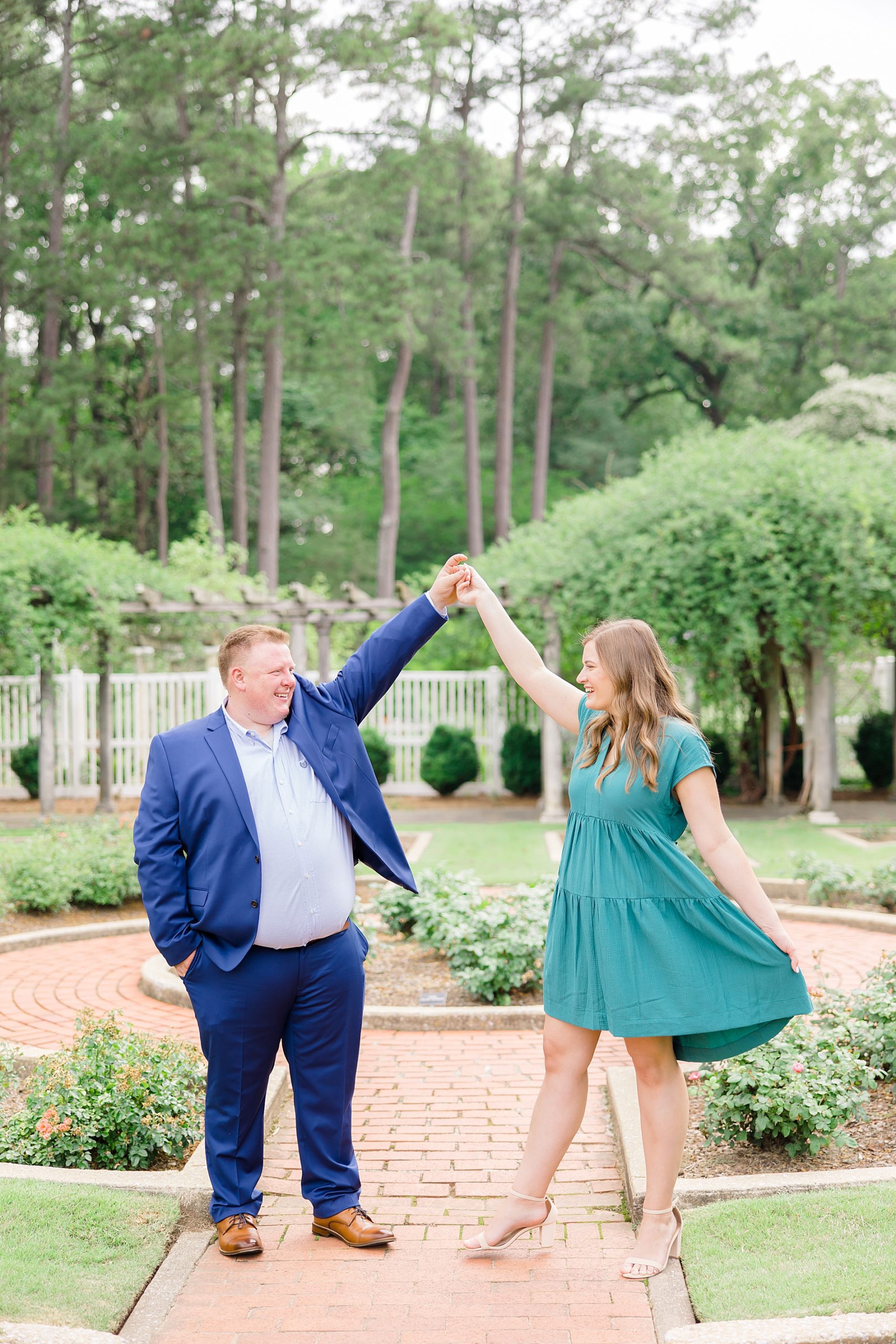 couple dances in the garden during engagement session