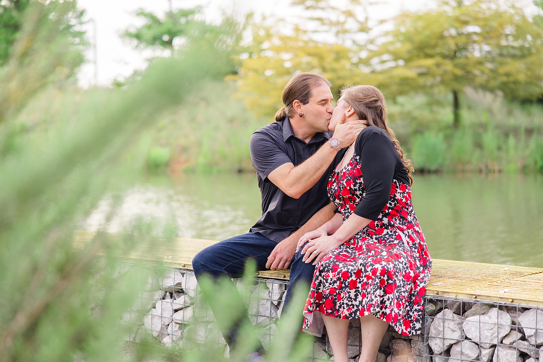 couple sit by the water during engagement session
