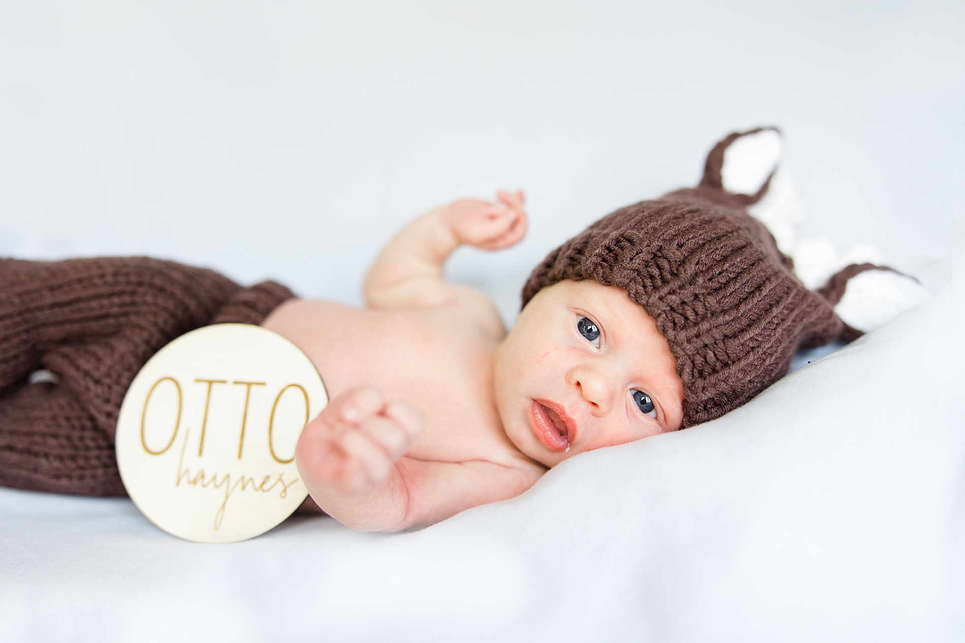 newborn boy in knitted outfit during in-home newborn portraits