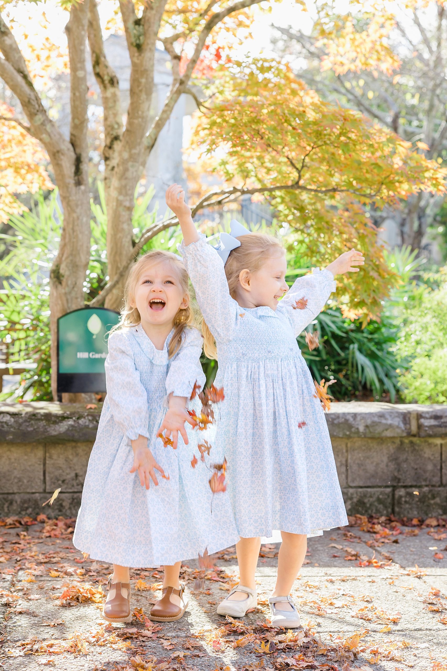 two sisters play in the leaves during Birmingham Family Session