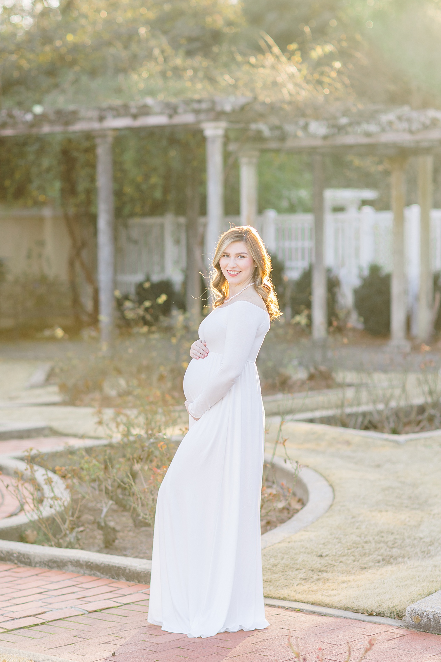 woman in white dress during maternity portraits 