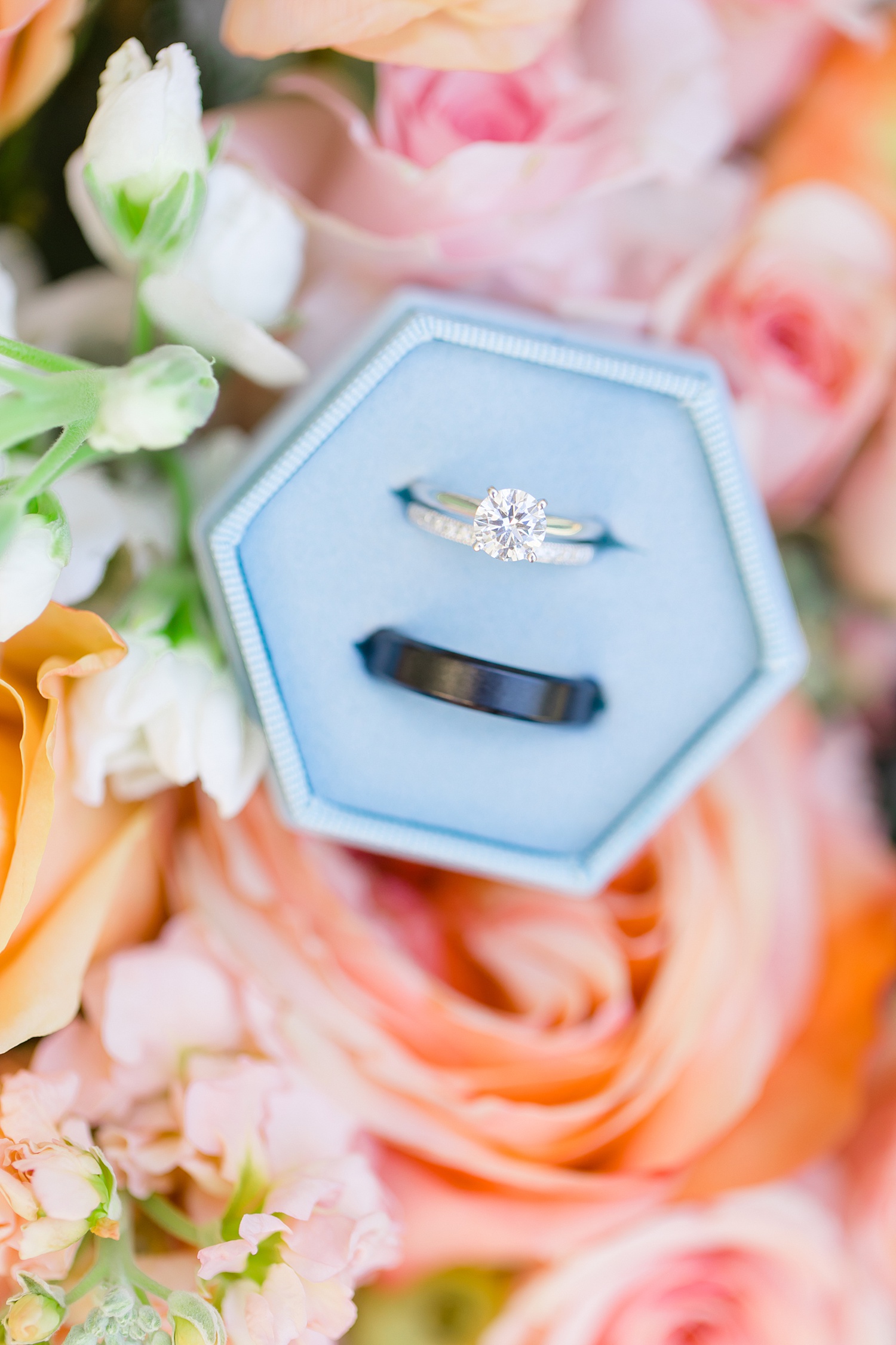 wedding rings featured on peach and white colored flowers