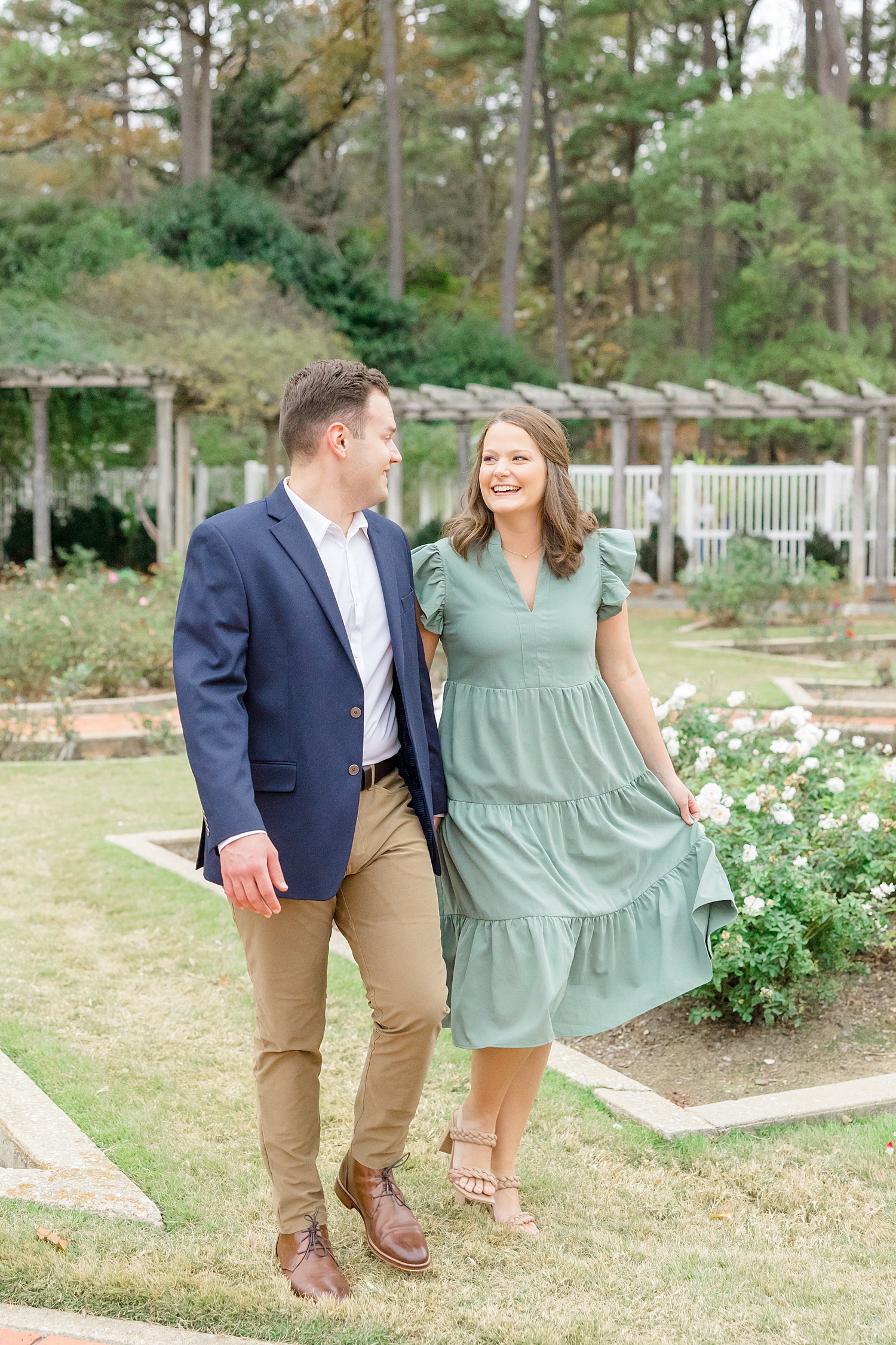 couple walk through gardens during engagement