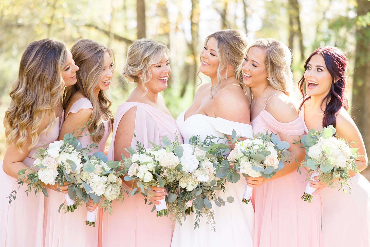 bridal party in light pink dresses and white flower bouquets