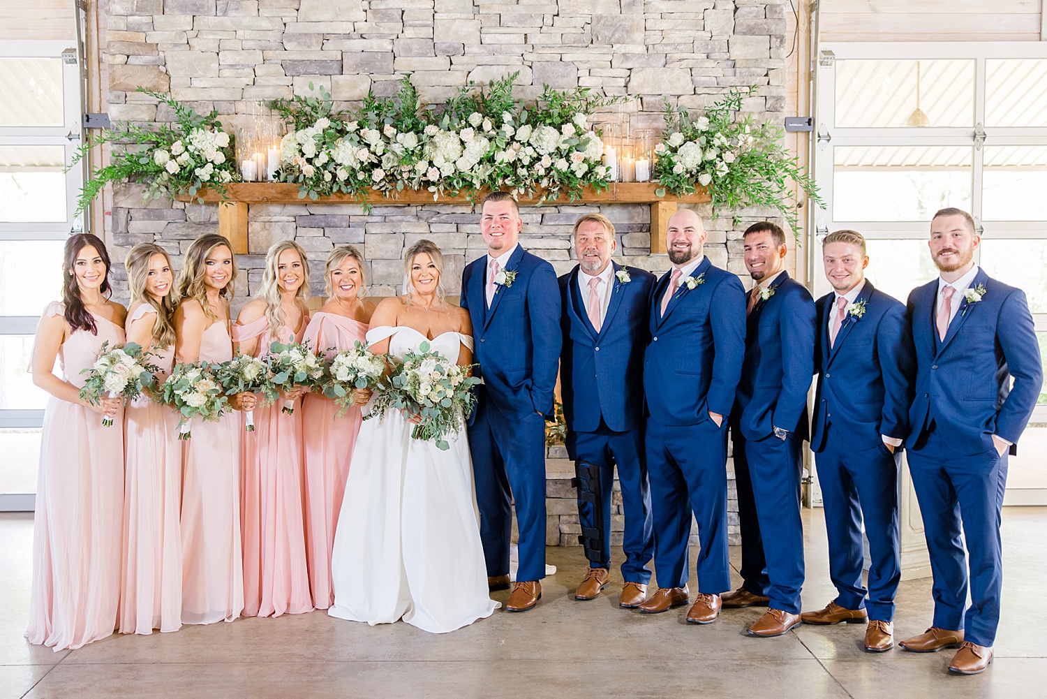 wedding party by stone fireplace at Mathews Manor in Springville, AL