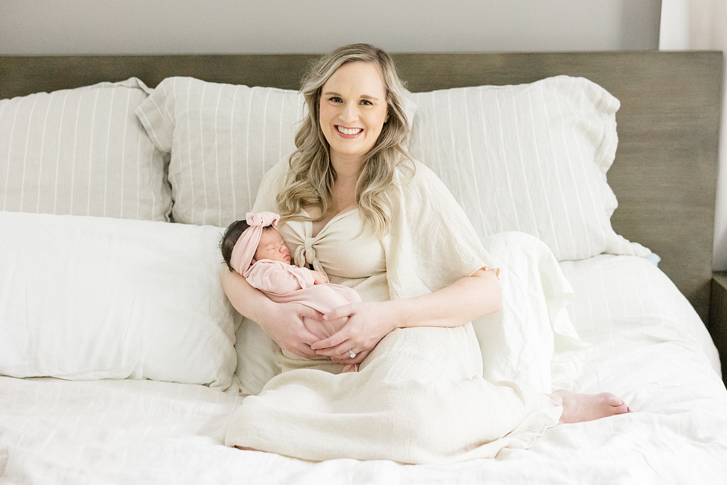 mom holds newborn girl during In-Home Newborn Session