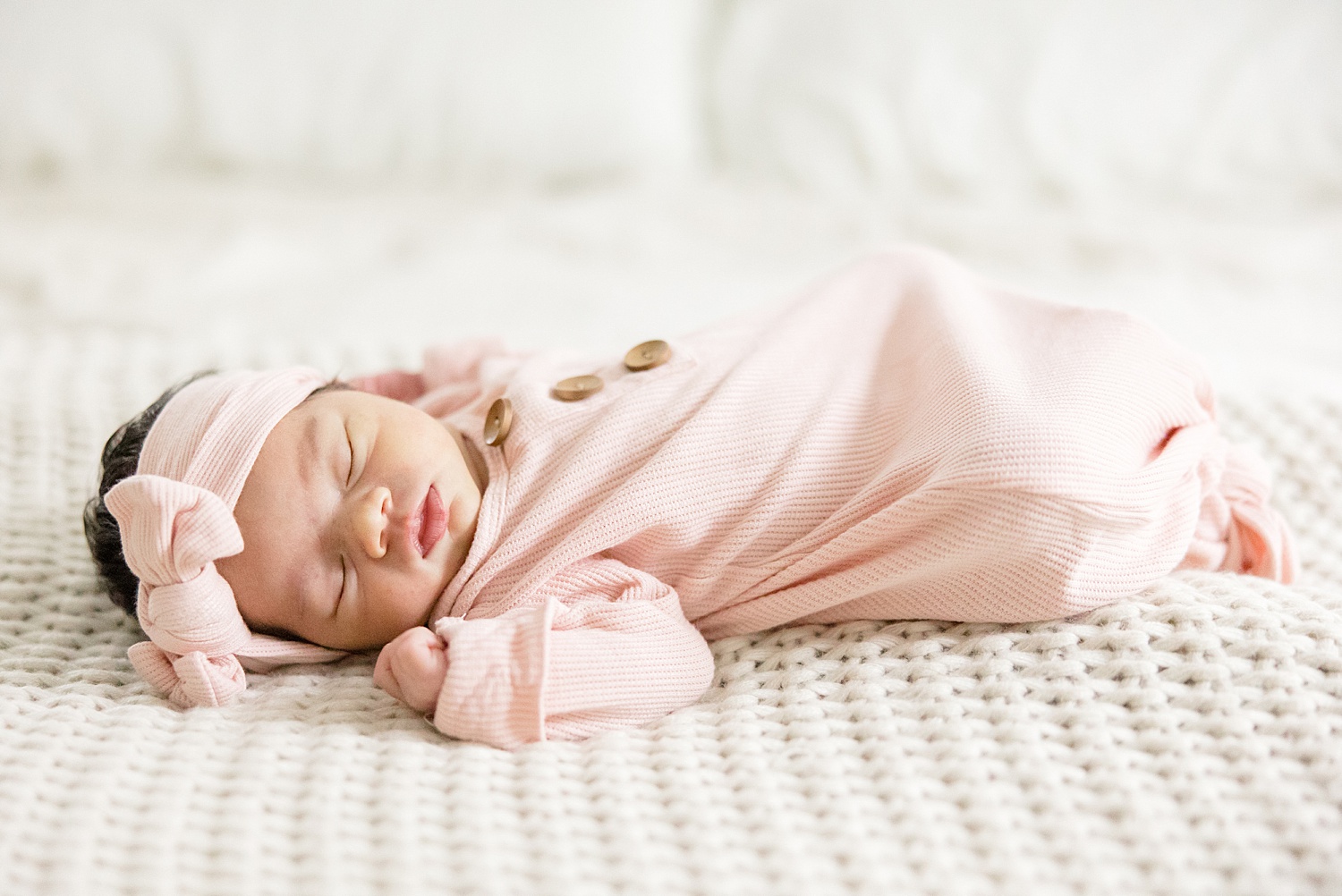 baby girl sleeps on bed during newborn session