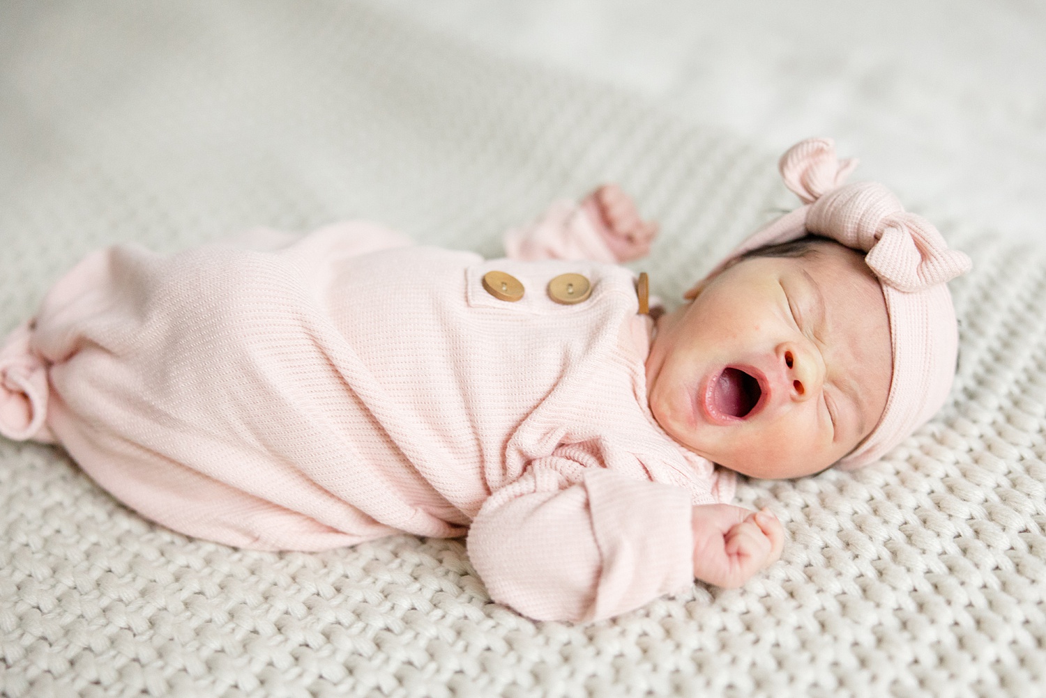 newborn girl yawns in her sleep