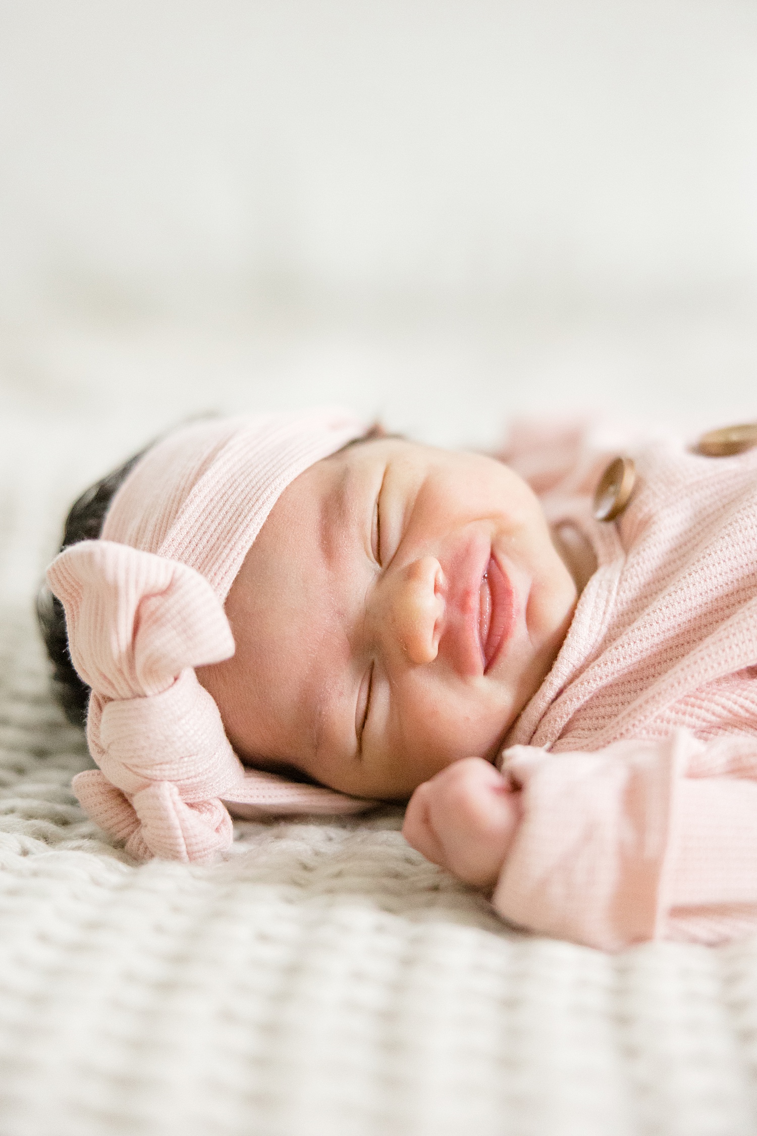 newborn smiles in her sleep during In-Home Newborn Session by Birmingham Newborn Photographer Chelsea Morton