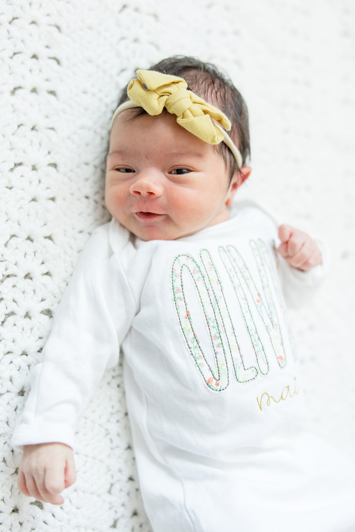sweet baby girl smiles at camera during newborn session in Birmingham