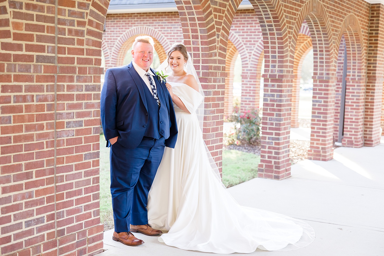 bride and groom under brick archway