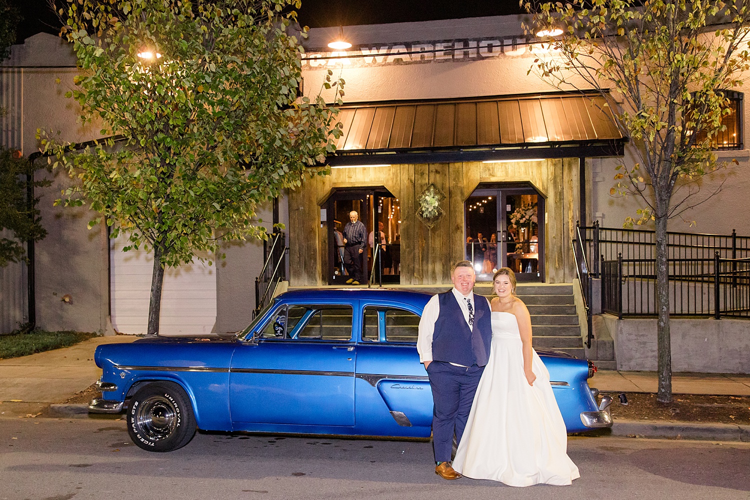bride and groom in front of classic car