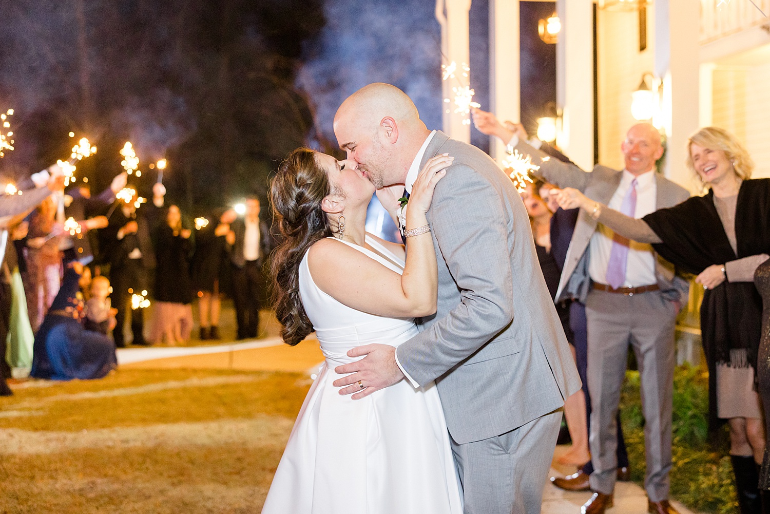 couple kiss during sparkler exit at Birmingham Wedding at Camelot Manor 
