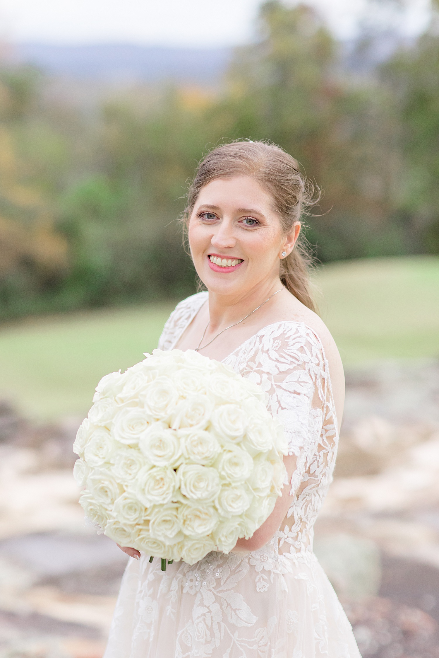 bride holding a stunning white rose bridal bouquet 