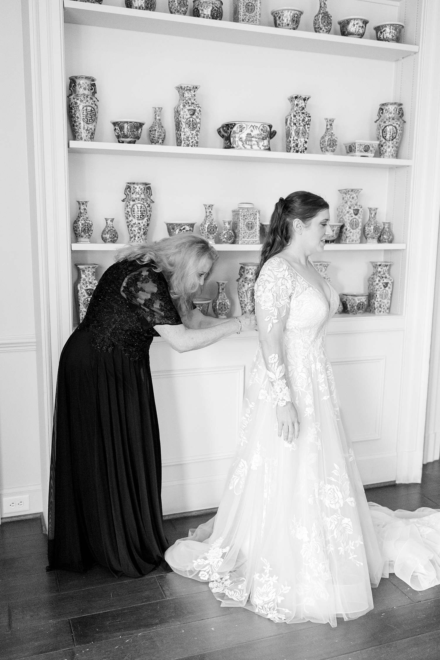 mother helps daughter into wedding dress