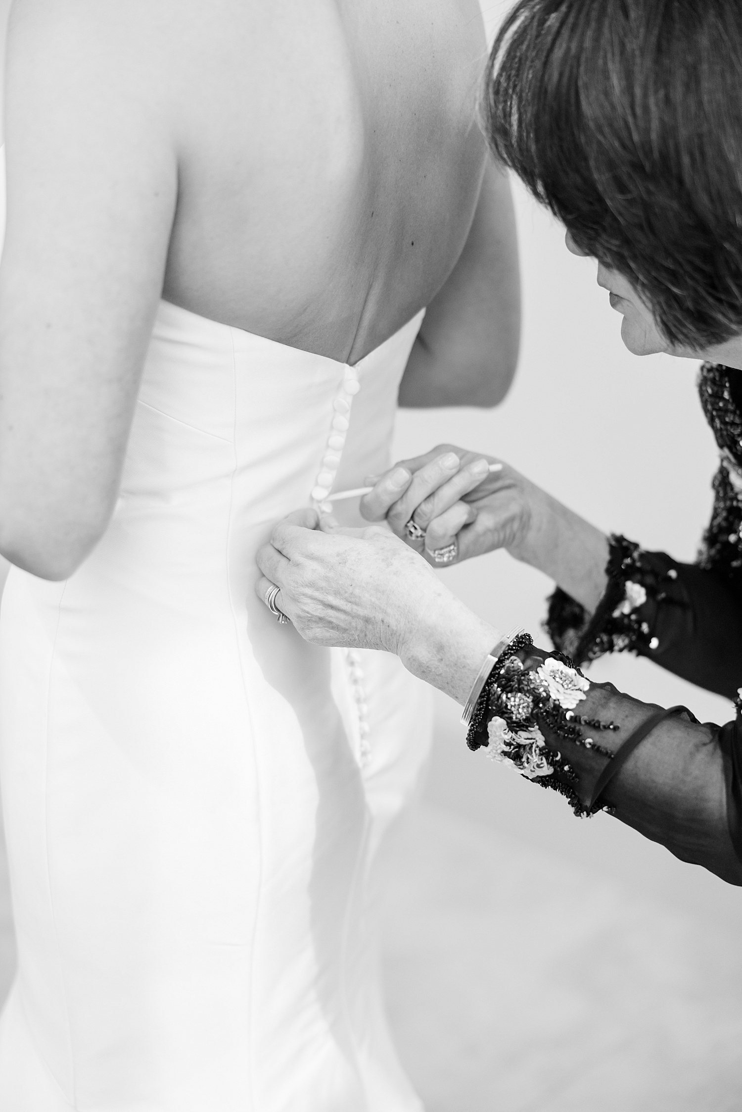 mom helps daughter in wedding dress