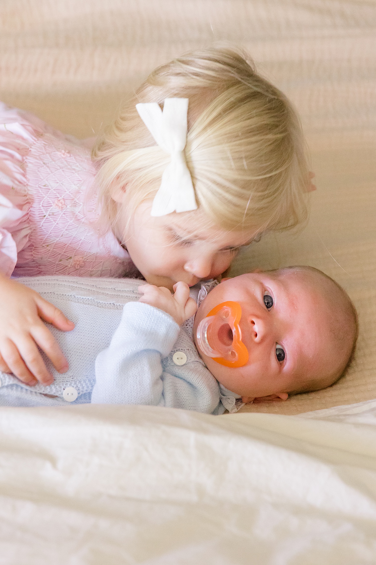 little girl snuggles her baby brother 