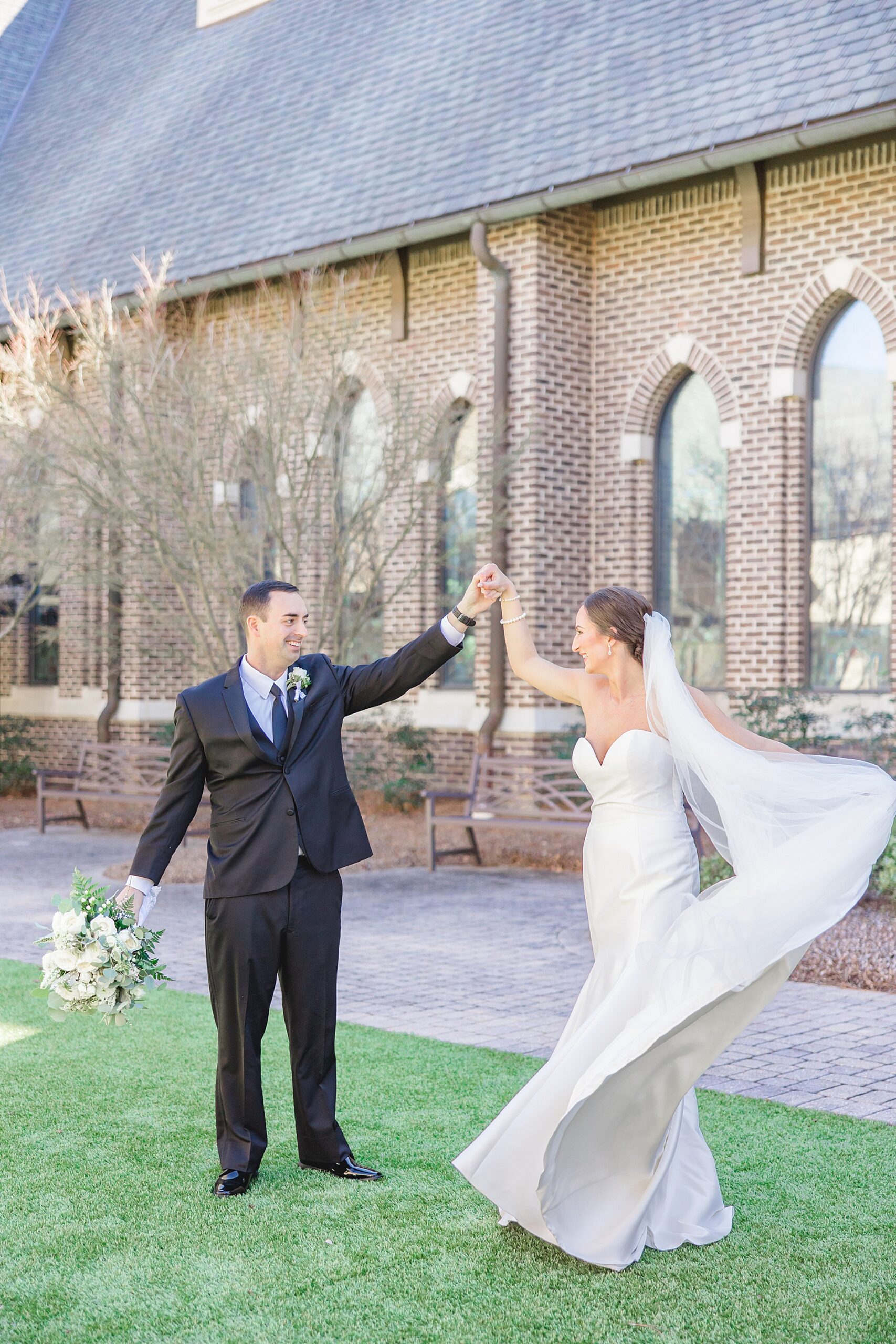 groom twirls bride outside of church 