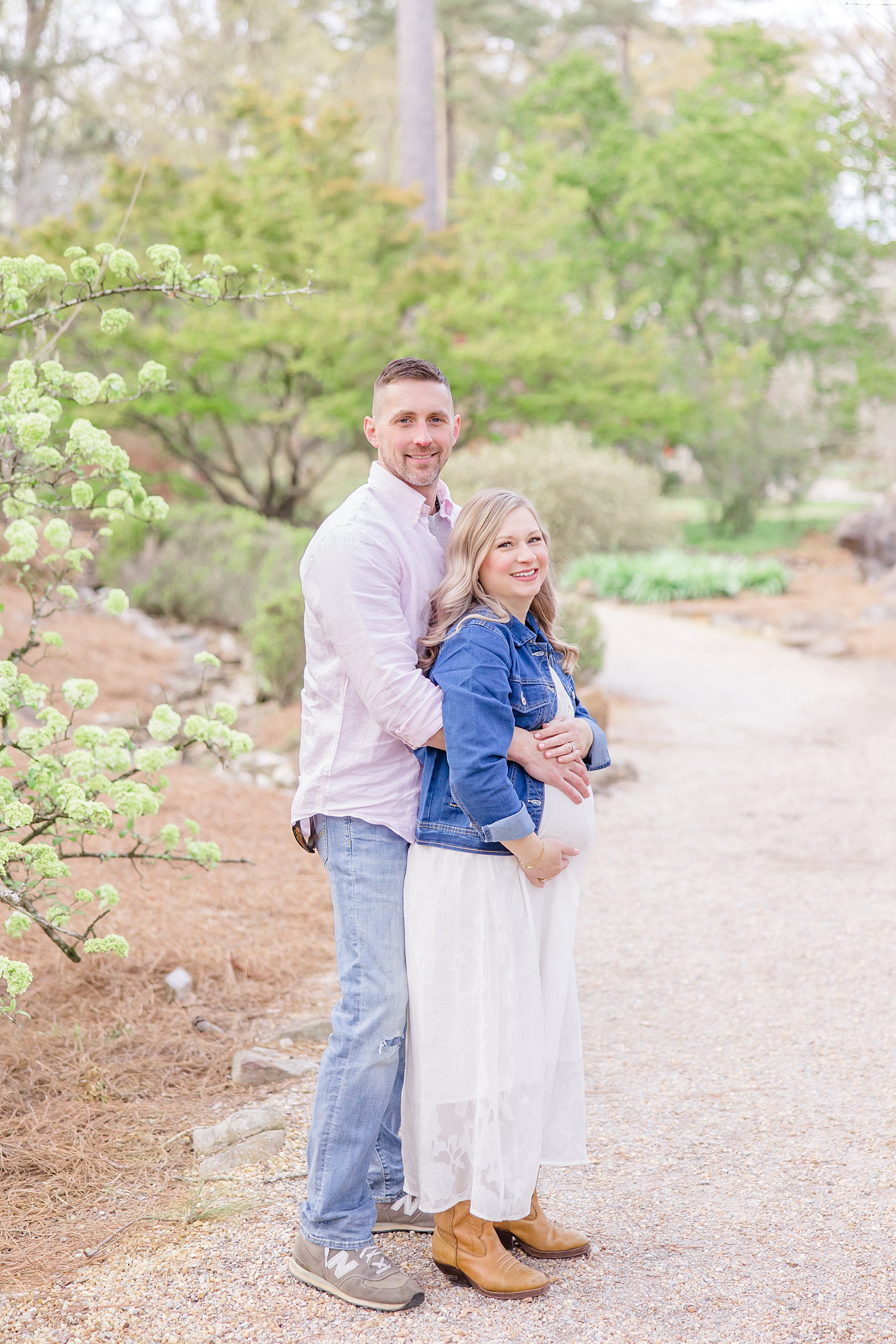 husband stands behind pregnant wife during Spring Botanical Garden Maternity session