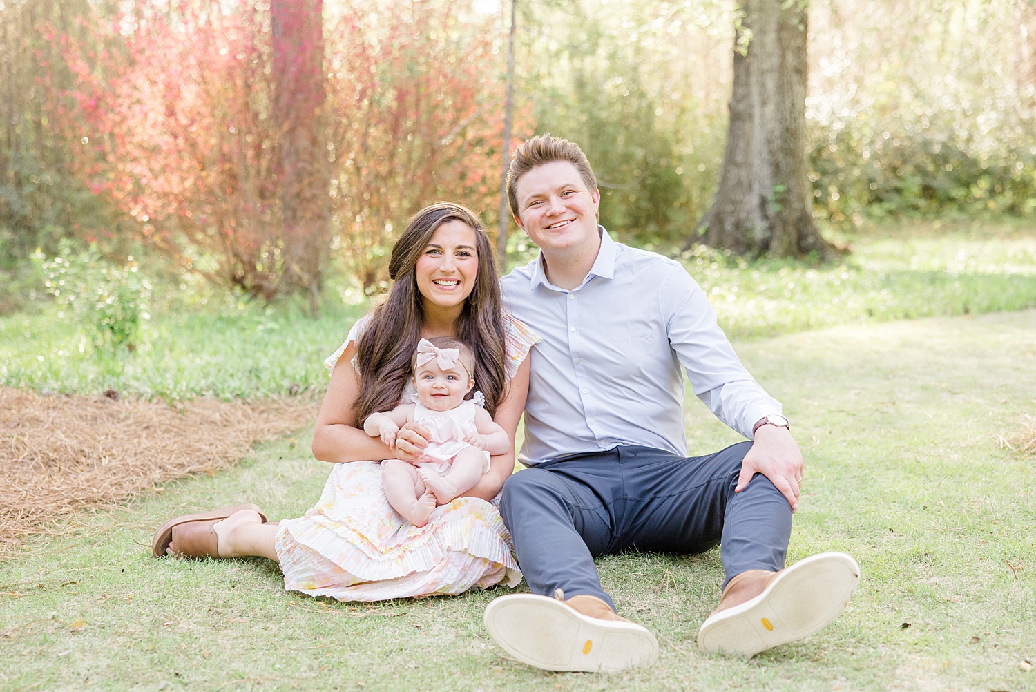 family of three sits on ground during Spring Mini Sessions at Birmingham Botanical Gardens